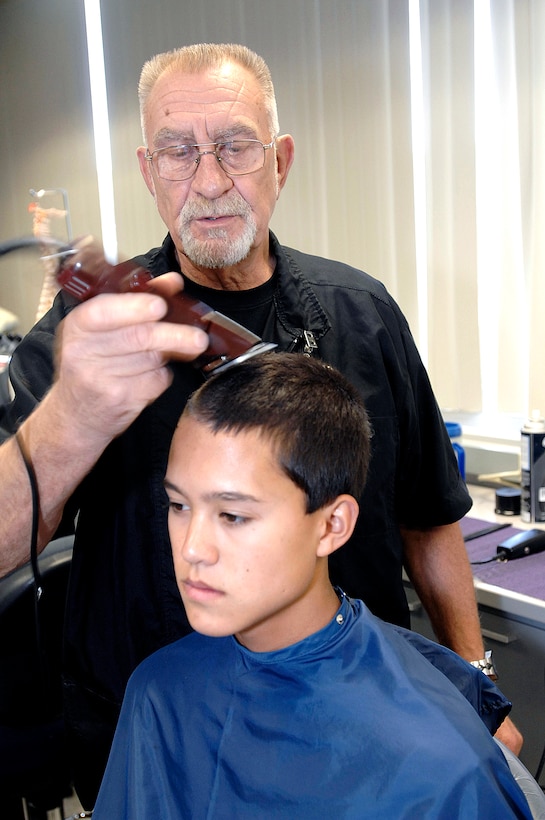 Basic Cadet Tate Montgomery receives his haircut from Gerd Siedler during in-processing at the U.S. Air Force Academy, Colo., June 26, 2008. The 1,369 members of the Class of 2012 arrived to begin Basic Cadet Training. Siedler has cut the hair of basic trainees there for 20 years.