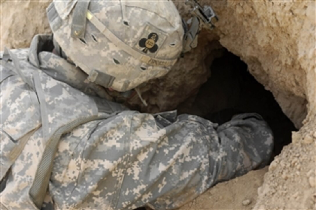 A U.S. Army soldier from 1st Platoon, Bravo Battery, 2nd Battalion, 320th Field Artillery Regiment searches for weapons caches during a combat operation in Yathreeb, Iraq, on June 28, 2008.  