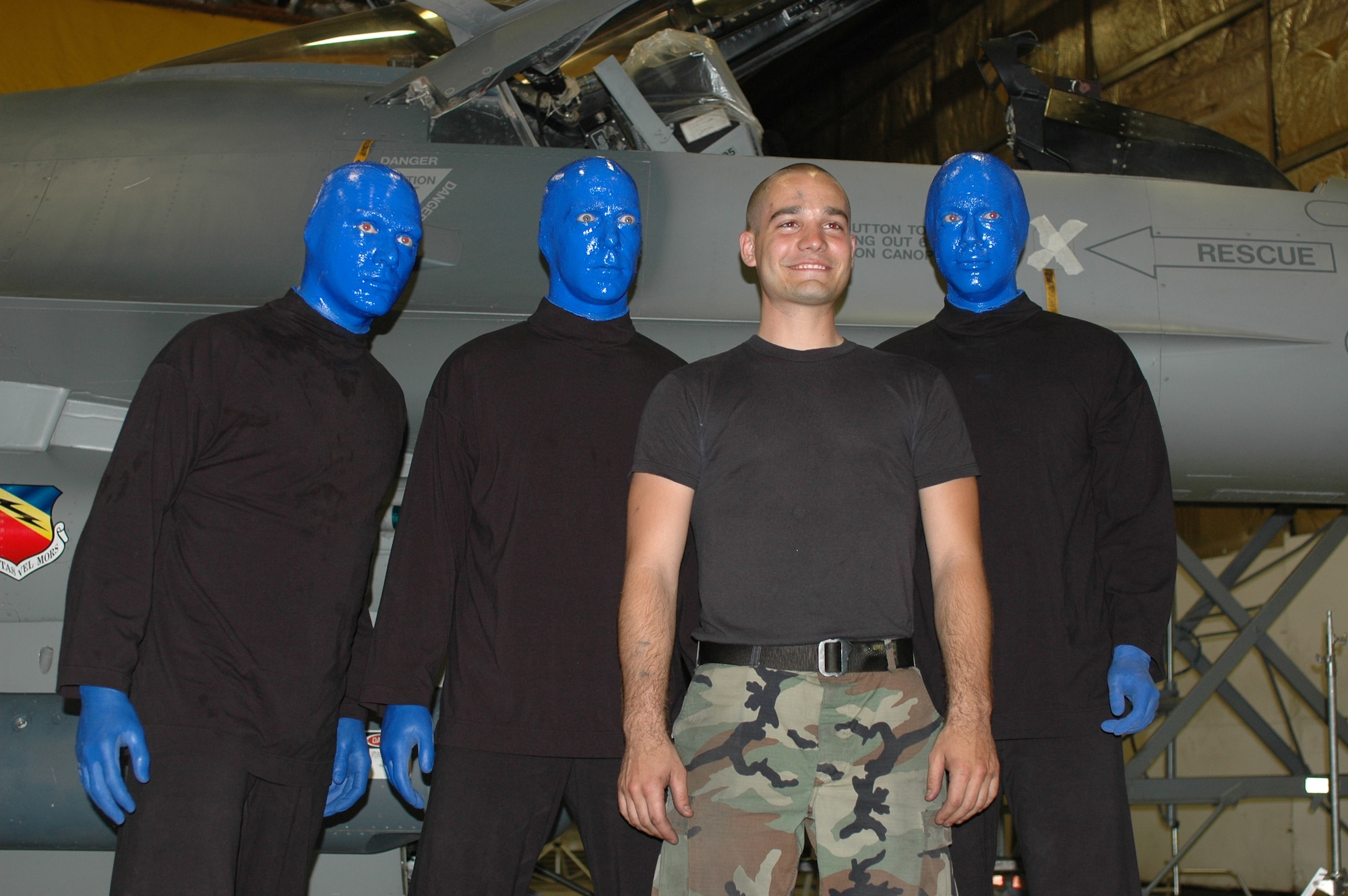 Airman 1st Class John Witlock, 4th Aircraft Maintenance Unit assistant dedicated crew chief, poses with members of the Blue Man Group following filming July 2. The Las Vegas entertainment act visited Hill AFB to shoot a welcome video for Provo, Utah's Stadium of Fire Fourth of July celebration. The 388th Fighter Wing will perform a four-ship flyover at the event to mark the patriotic holiday and thank community members for their support of the Air Force mission. (Photo by 1st Lt. Beth Woodward)