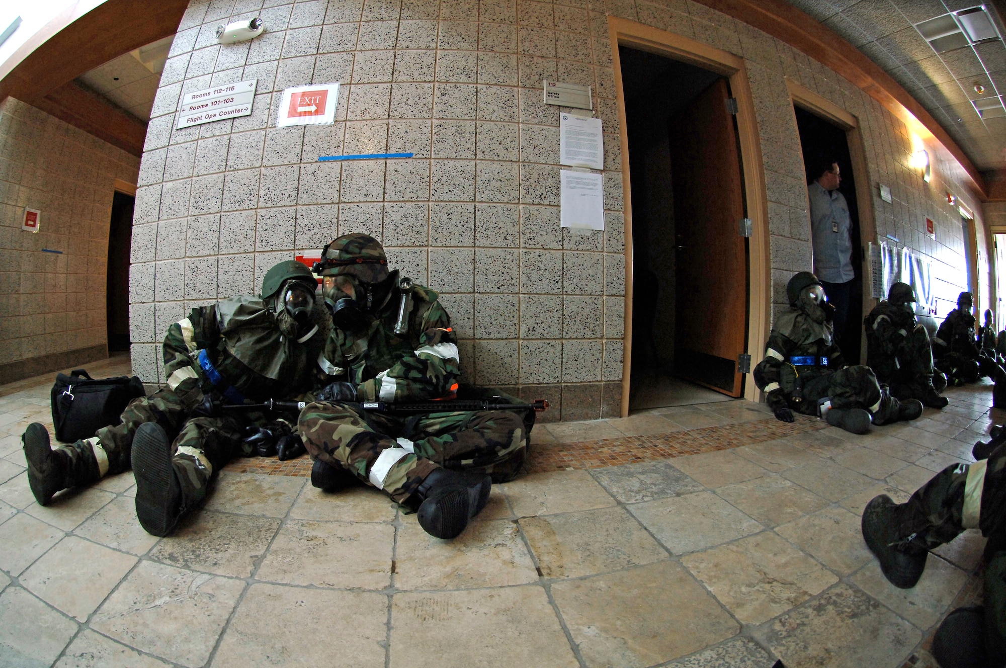 Squadron Operations Center members wait communicate through their gas masks at an Operational Readiness Inspection at Volk Field Air National Guard Base, Wis., on June 26. The active-duty Airmen wearing the blue reflective belt deployed to the inspection from the 22nd Air Refueling Wing at McConnell Air Force Base, Kan.  The Airmen wearing the orange belt was deployed by the 134th Air Refueling Wing, an Air National Guard unit from Tennessee. (U.S. Air Force photo/Senior Airman Laura Suttles)