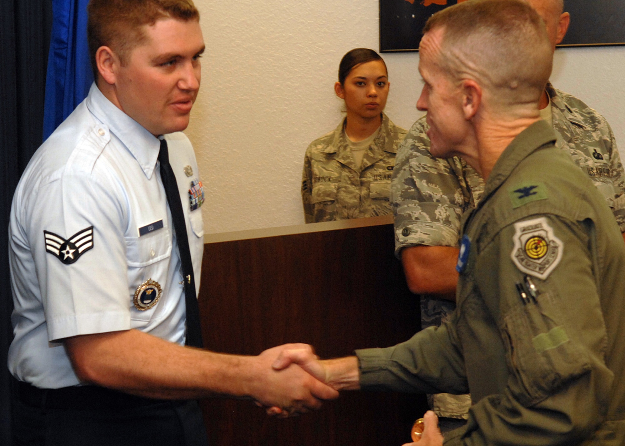 Col. Kent Laughbaum, 355th Fighter Wing commander, congratulates Senior Airman Michael Gisi, 362nd Recruiting Squadron, for his selection as one of five finalists in the Davis-Monthan Air Force Base Idol contest in Ariz. Staff Sgt. Christopher Forman, not shown, 362nd RCS, also made the cut from 17 singers. The recruiters move on to compete in the Tucson Idol contest July 11. The contest, sponsored by the Davis-Monthan AFB Top 6 and the Tucson Committee, offers Airmen a safe and positive social outlet. (U.S. Air Force photo)