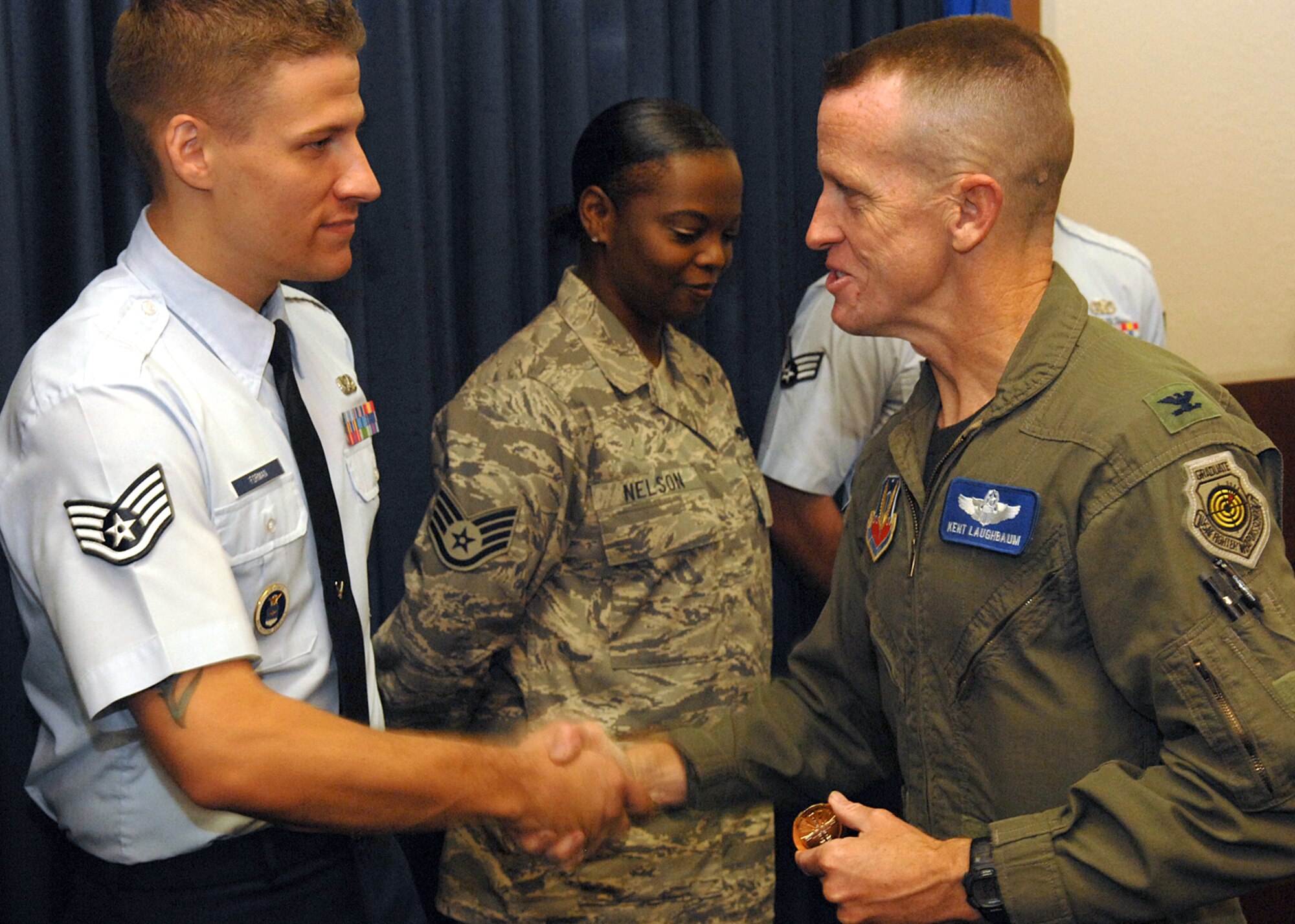 Col. Kent Laughbaum, 355th Fighter Wing commander, congratulates Staff Sgt. Christopher Forman, 362nd Recruiting Squadron, for his selection as one of five finalists in the Davis-Monthan Air Force Base Idol contest in Ariz. Senior Airman Michael Gisi, not shown, 362nd RCS, also made the cut from 17 singers. The recruiters move on to compete in the Tucson Idol contest July 11. The contest, sponsored by the Davis-Monthan AFB Top 6 and the Tucson Committee, offers Airmen a safe and positive social outlet. (U.S. Air Force photo)
