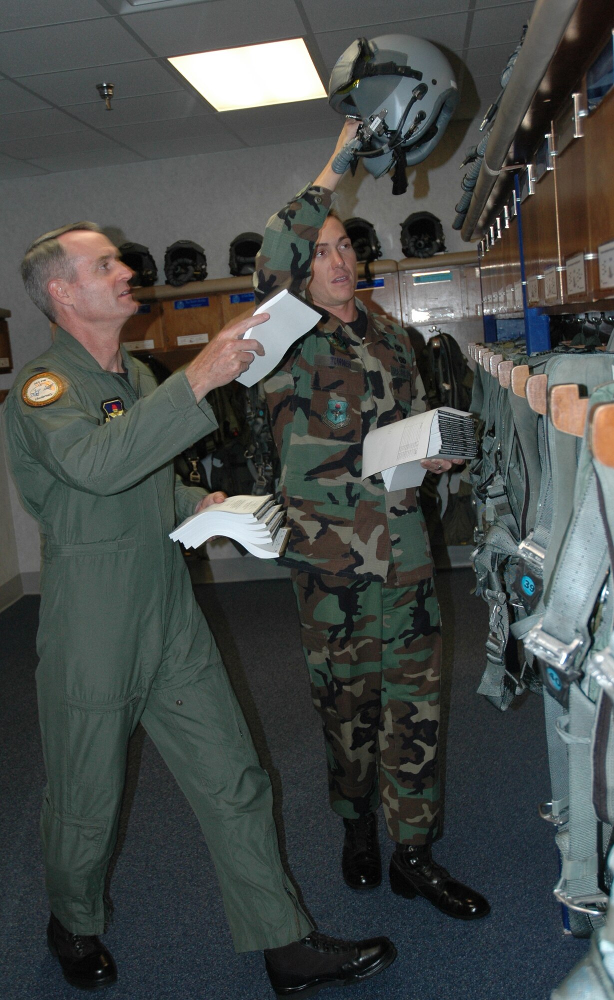 Col. Darryl Roberson, 325th Fighter Wing commander, assists Senior Airman Adam Turner, 95th Fighter Squadron aviation resource manager, distribute flight publications to pilot lockers. Airman Turner, selected for the Commander’s Shadow Program, is responsible for maintaining the Aviation Resource Management System pertaining to aircraft operations, flying hour utilization and pilot training.  “Airman Turner bleeds Air Force blue and is truly tops amongst his peers,” said Tech. Sgt. Givonnie Jackson, Airman Turner’s supervisor and nominator. Serving the Air Force for eight years, Airman Turner hails from Jacksonville, Fla. (U.S. Air Force photo by Staff Sgt. Timothy Capling) 