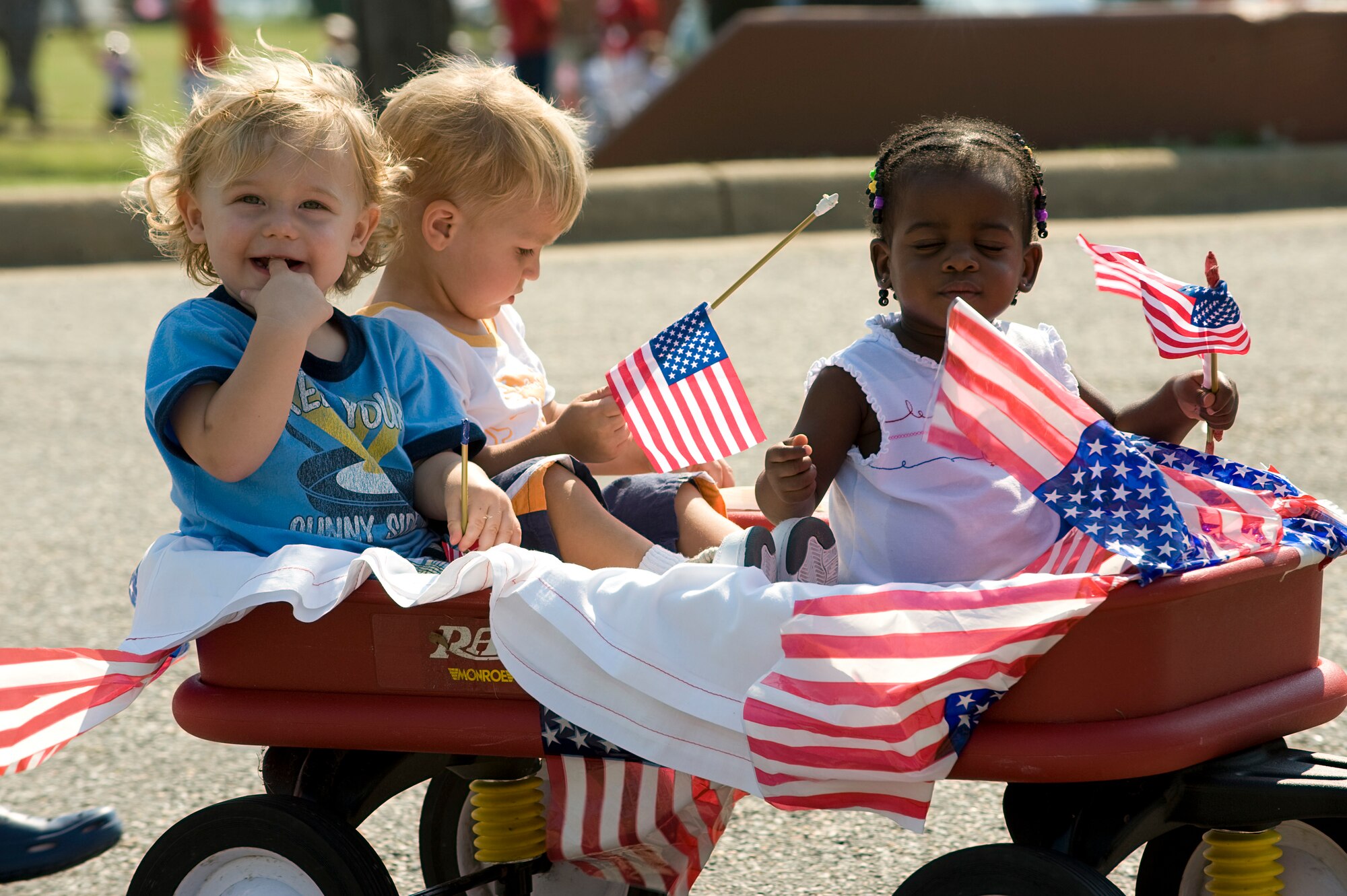 LANGLEY AIR FORCE BASE, Va. -- Children ride in the Red, White and Blue parade outside of the Russ Child Development Center July 3.  The CDC holds the parade annually to celebrate Independence Day.  (U.S. Air Force photo/Staff Sgt. Barry Loo)