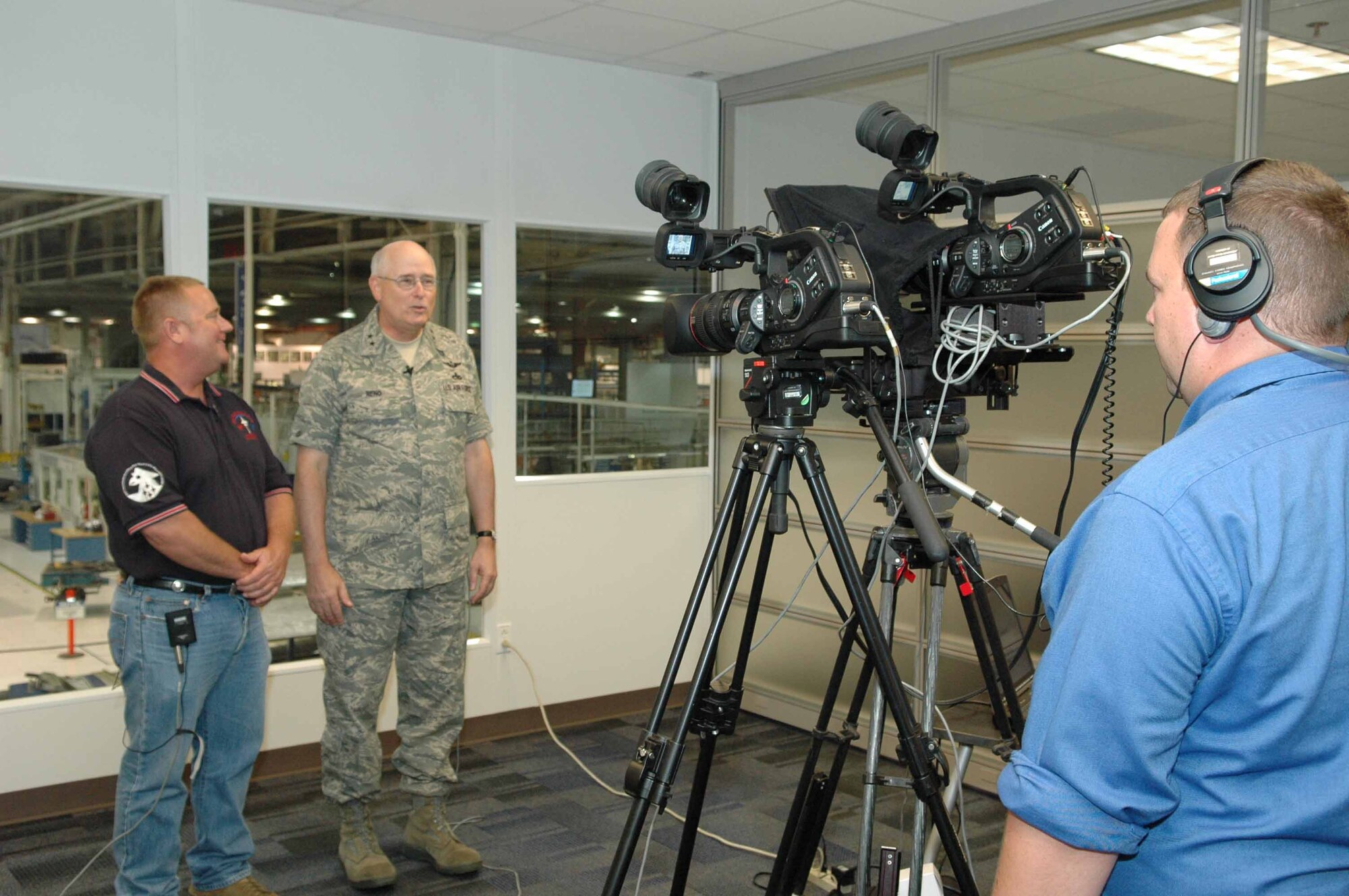 Tony Channel, site manager for KMAR Industries, videotapes Oklahoma City Air Logistics Center Commander Maj. Gen. Loren Reno and Johnny Johnson, an aircraft towing supervisor with the 566th Aircraft Maintenance Squadron June 26 in Bldg. 3001, as part of a special message to the work force by General Reno.  The video will soon be on the Tinker home page.  (Air Force photo by Ron Mullan)
