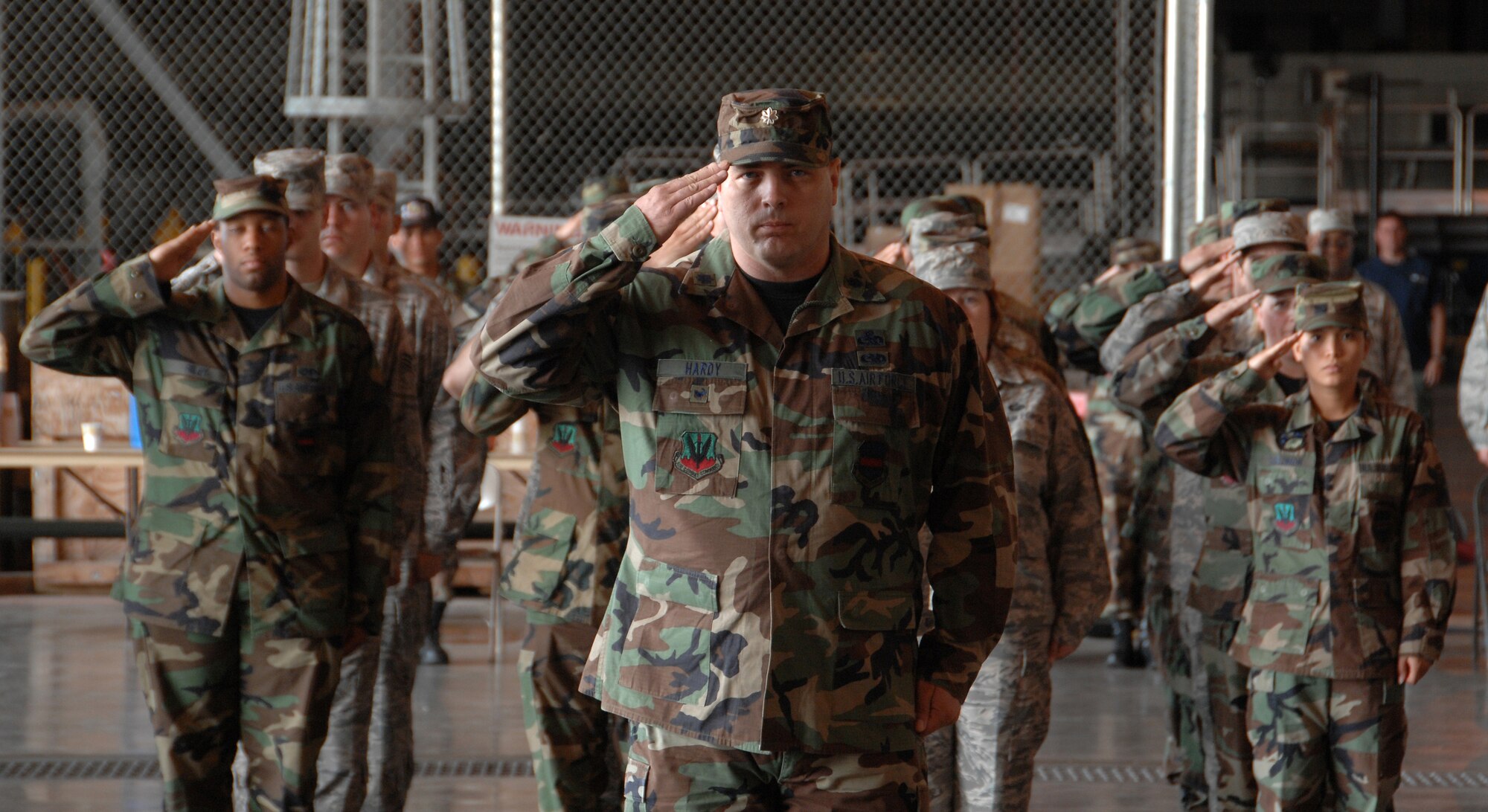 Lieutenant Col. Steve B. Hardy, commander of troops for the ceremony, and 55th Maintenance Group Airmen salute the incoming commander at the ceremony held in the Bennie Davis Maintenance Facility. (U.S. Air Force Photo /Josh Plueger)