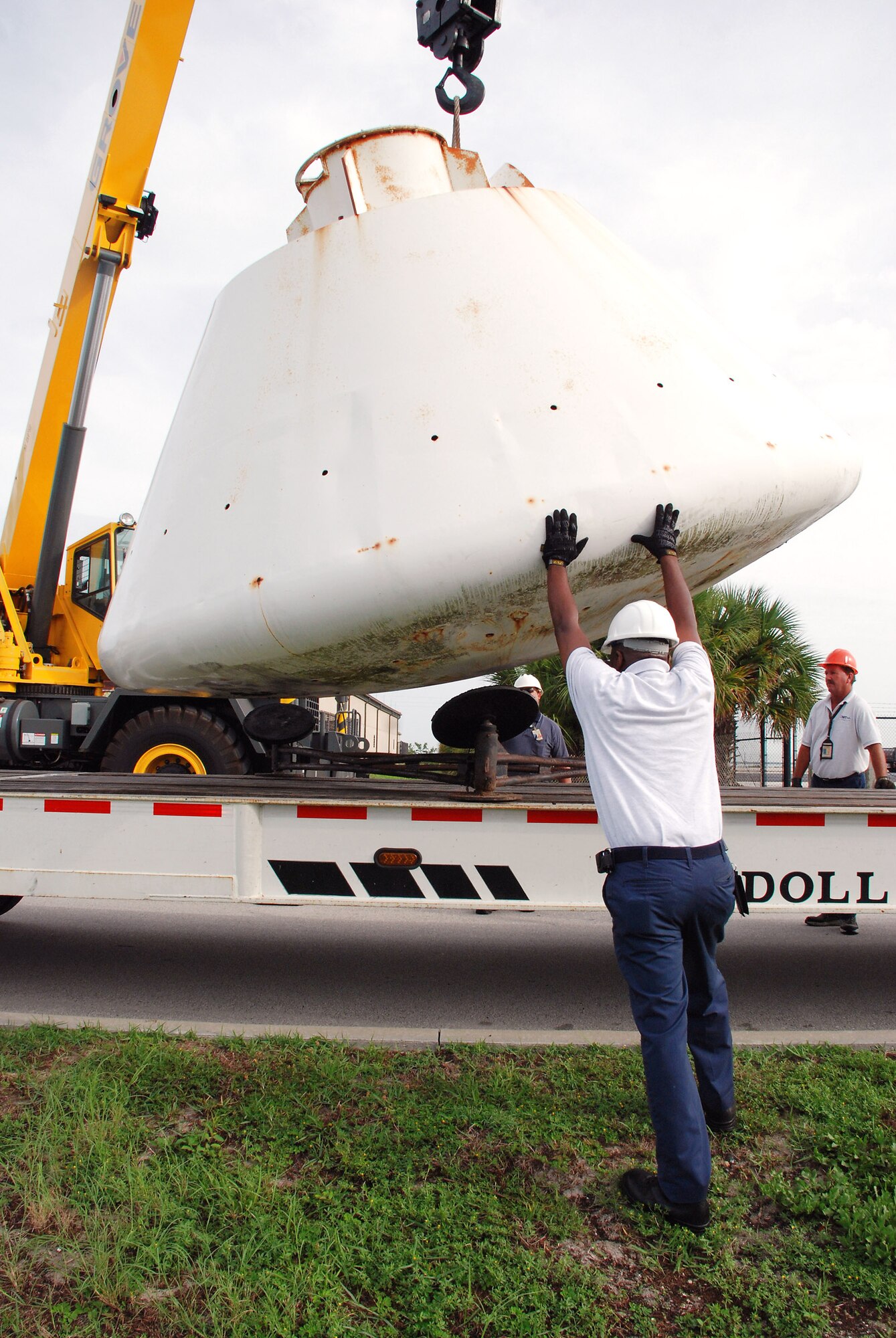 Workers help guide the 9,000-pound Apollo Boilerplate #1206 capsule onto a flatbed truck for transportation to a local refurbishment facility July 1 at Patrick Air Force Base, Fla. On loan here to the Air Force Reserve's 920th Rescue Wing from the Smithsonian Institute's Air and Space Museum, the capsule was once used by Air Force rescue units to train for astronaut recovery during the Apollo and Skylab space programs. (U.S. Air Force photo/Capt. Cathleen Snow) 