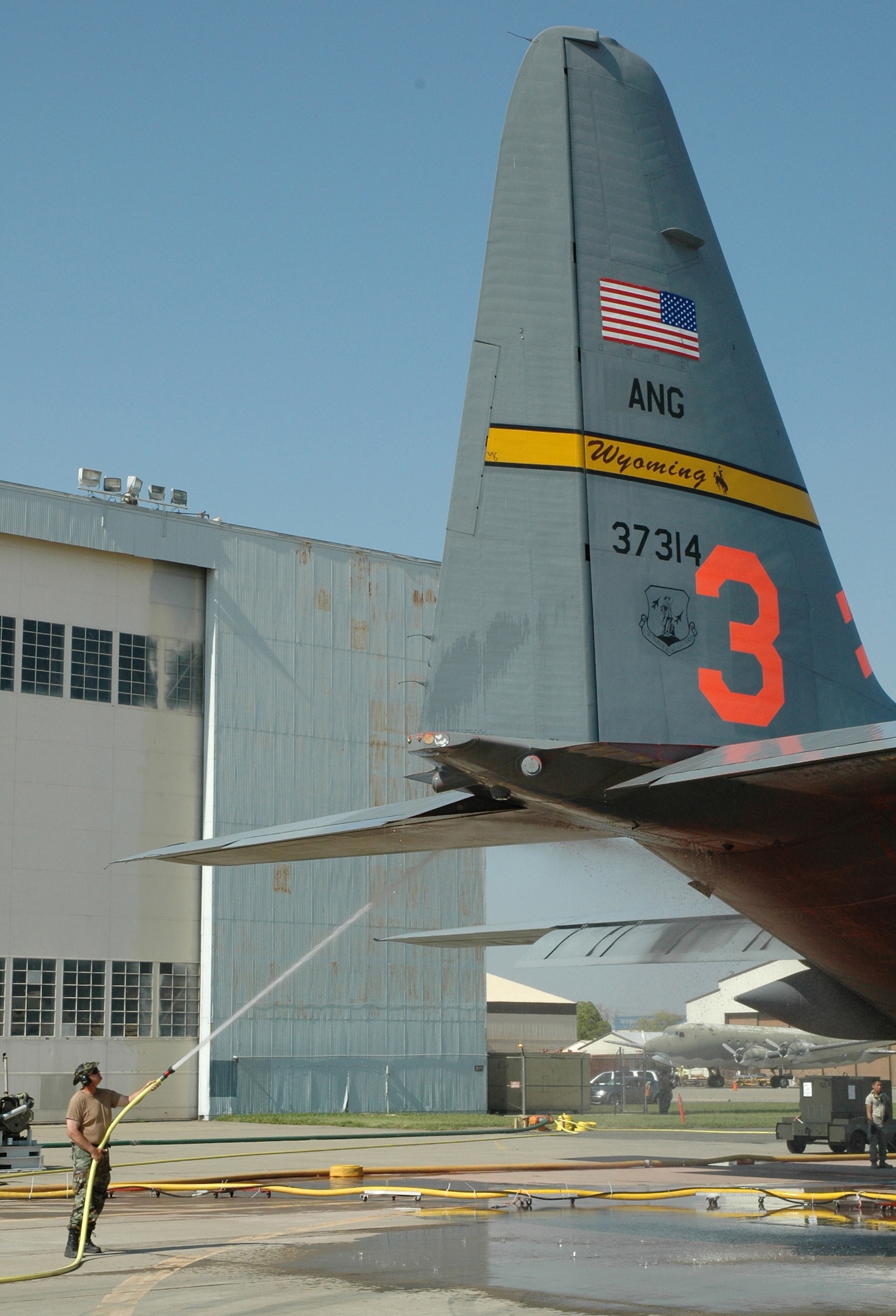 SACRAMENTO, Calif.- An Airman with Wyoming?s Air National Guard 153rd Airlift Wing washes down a C-130H July 1 at McClellan Airfield in Sacramento, Calif. The C-130H is currently assigned to the 302nd Air Expeditionary Group.  The 302nd Air Expeditionary Group?s C-130 aircraft include aircraft from two Air National Guard units, the 153rd Airlift Wing of Cheyenne, Wyo., and the 145th AW of Charlotte, N.C. and one Air Force Reserve unit, the 302nd AW from Peterson Air Force Base, Colo.  The C-130 aircraft?s deployed location in Sacramento allows the aircraft to fly with maximum fuel loads and operate MAFFS with a nearly full fire retardant capacity, flying support of California Department of Forestry and Fire Protection and U.S. Forest Service operations.  The 302nd AEG provides unique capabilities and is part of a unified military support effort of U.S. Northern Command to provide assistance to the U.S. Forest Service, CAL FIRE, and the National Interagency Fire Center. USNORTHCOM continues to closely monitor the California wildfires to anticipate additional requests for Department of Defense assistance to local, federal, and state civil authorities.  (U.S. Air Force Photo by Staff Sergeant Luke Johnson)