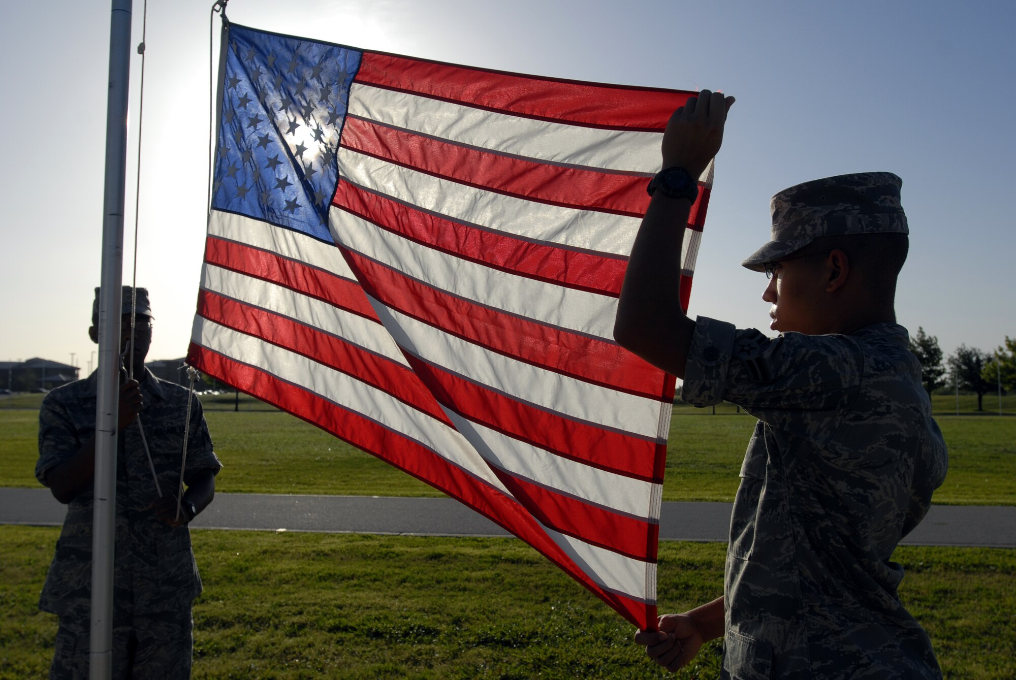 Airman Bryant Thompson and Airman First Class Kevin Stallings prepare to raise the colors Tuesday. (U.S. Air Force photo by Master Sgt. Randy Mallard)