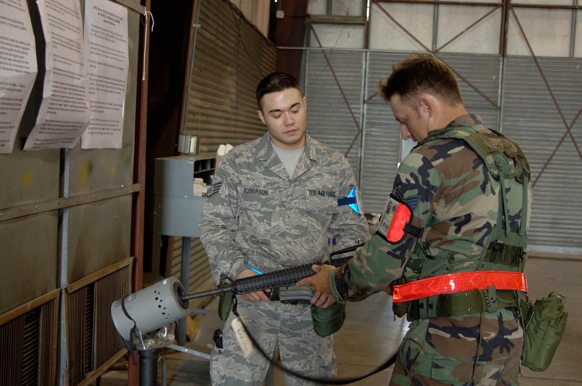 Staff Sgt. Sean Roberson helps ensure Tech. Sgt. Nabil Abdul-Kader's weapon is not loaded during an Operational Readiness Exercise at Volk Field Air National Guard Base, Wis.  The exercise ended June 29 and was declared a total force success during an outbrief at McConnell Air Force Base, Kan., on July 3.  Sergeant Abdul-Kader is a member of the 931st Civil Engineer Squadron, the Air Force Reserve unit at McConnell, and Sergeant Roberson deployed toVolk as an augmentee from the 22nd Air Refueling Wing at McConnell. (U.S. Air Force photo/Senior Airman Laura Suttles)