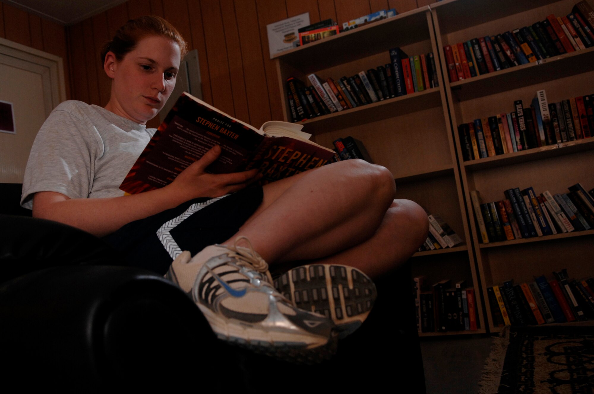 JOINT BASE BALAD, Iraq -- Senior Airman Heidi Ecker, 332nd Expeditionary Force Support Squadron services technician, reads a book at the Red Tail Library in the Housing 6 area here, July 1. The library offers a quiet place to sit down, relax and get lost in a favorite book. They have a diverse selection of books that are donated from various locations in the U.S. and are free to take. Airman Ecker is deployed from Beale Air Force Base, Calif. (U.S. Air Force photo/ Senior Airman Julianne Showalter)
