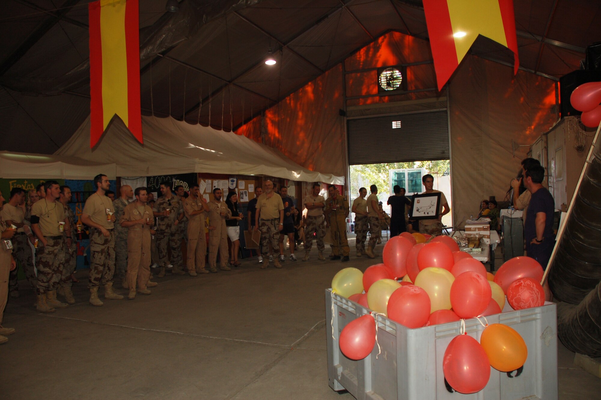 As contenders look on, Airmen of the Spanish “Mizar” detachment auction off artwork during the Bonfire of Saint John celebration at Manas Air Base, Kyrgyzstan, July 1. The auction, whose proceeds went to community outreach efforts, was one of many activities held during the celebration attended by several hundred Coalition personnel and Kyrgyz guests. (photo by Maj. Damien Pickart)