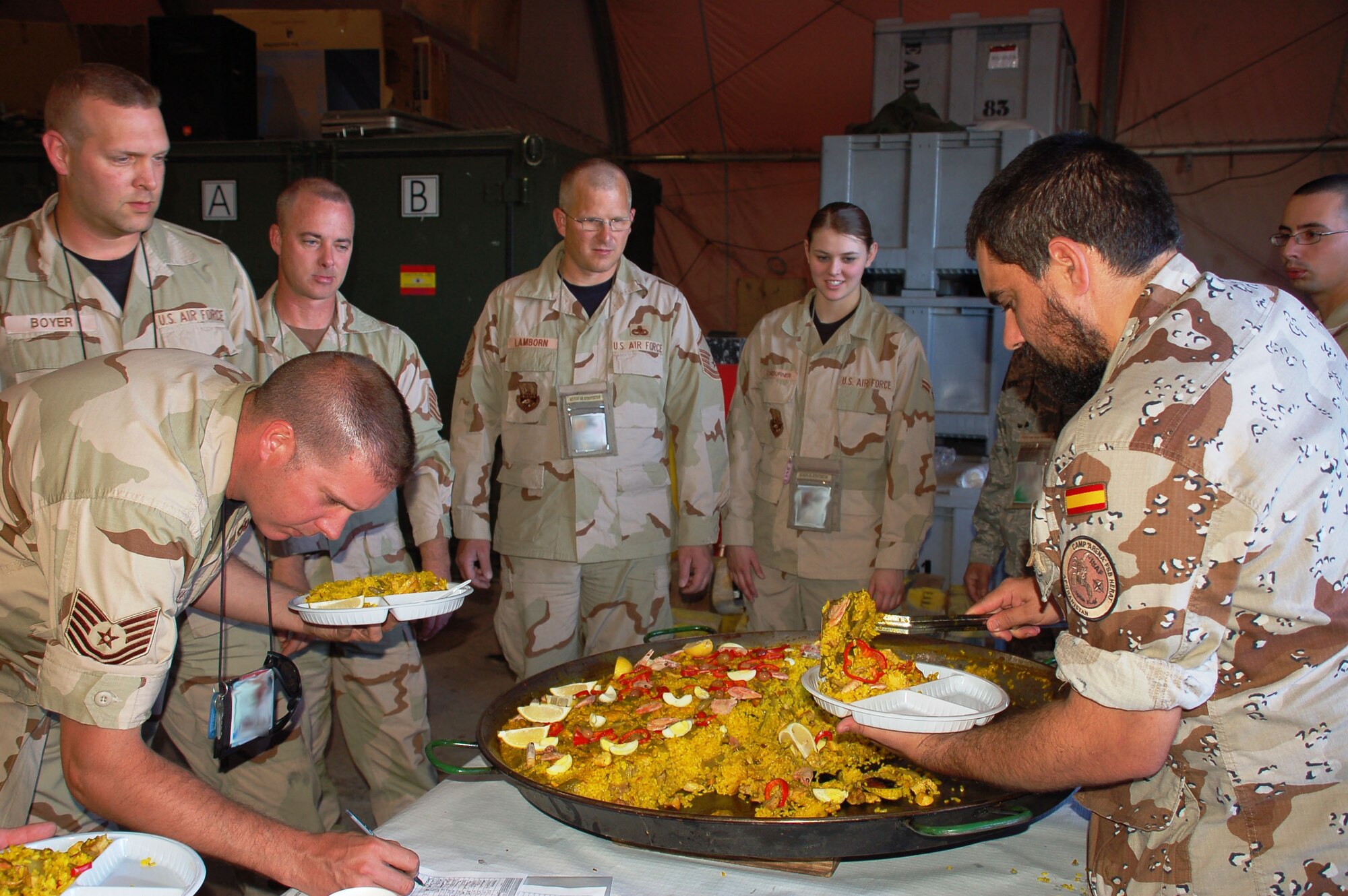 An Airman of Manas Air Base’s Spanish “Mizar” detachment here serves paella, a traditional Spanish dish, to Liberandos Airmen during the Bonfires of Saint John festival July 1. The Spanish Airmen invited several hundred Coalition personnel and local Kyrgyz guests to help observe the annual festival celebrated throughout Spain. (photo by Maj. Damien Pickart
