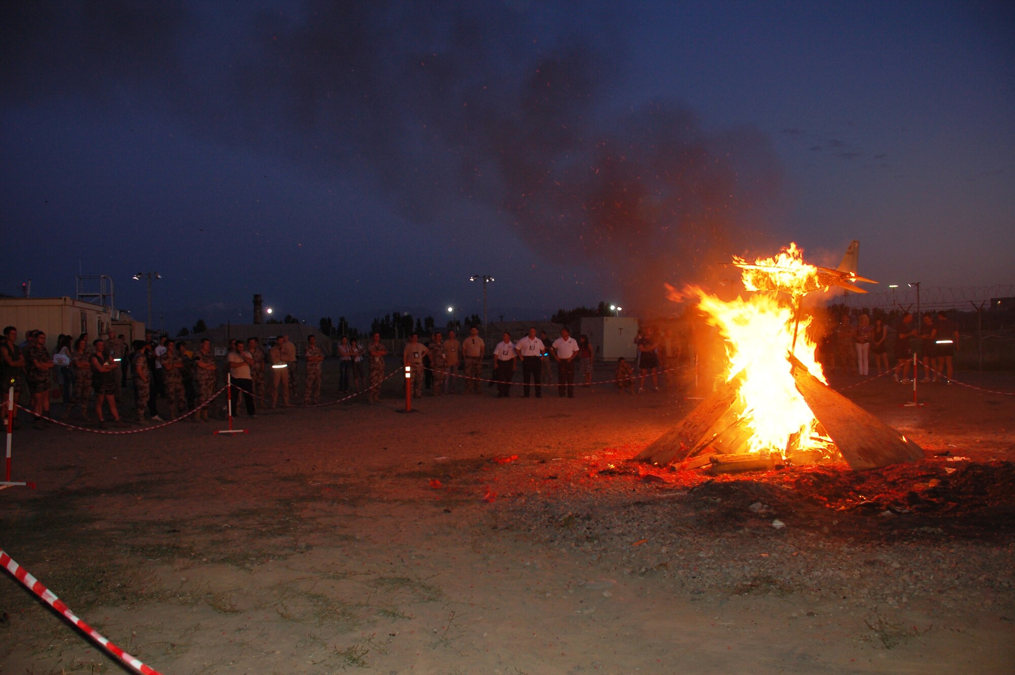 Coalition personnel and local guests cheer as flames from the Bonfire of Saint John leap into the night sky at Manas Air Base, Kyrgyzstan, July 1. Airmen from the Spanish “Mizar” detachment here invited several hundred Coalition personnel and local guests to help them observe the annual festival, traditionally celebrated in late June throughout Spain. (photo by Maj. Damien Pickart)
