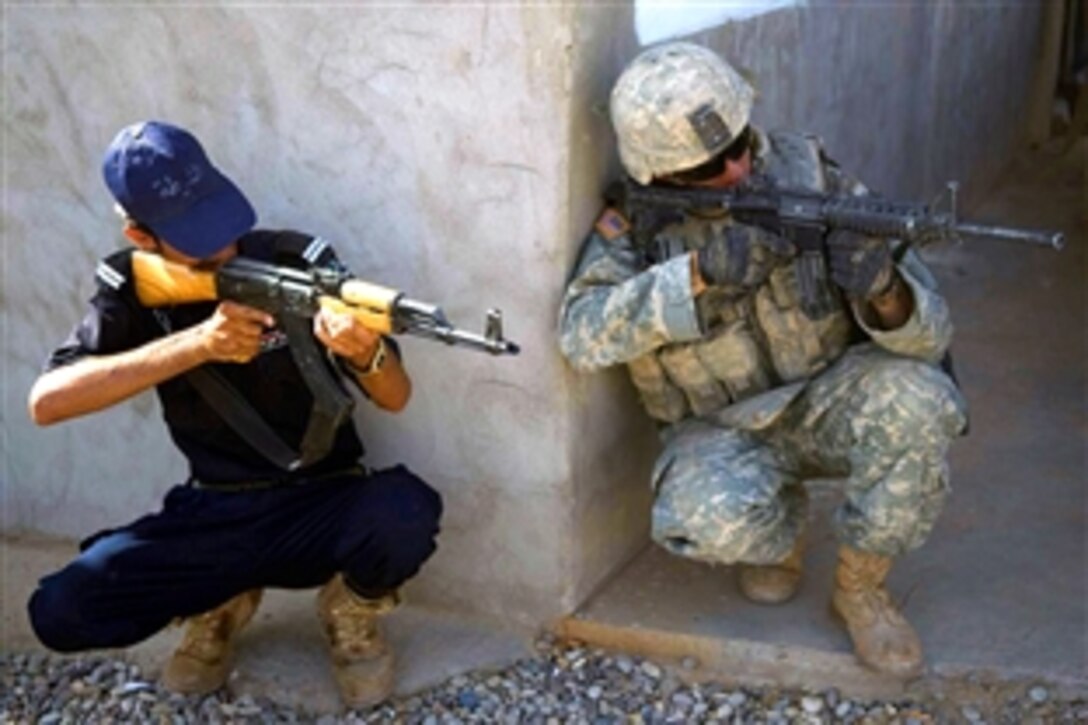 A U.S. soldier gives an impromptu lesson on aiming techniques to an Iraqi national policeman outside a building in Khanagin, Iraq, June 29, 2008. The soldier is assigned to the Fox Troop 2nd Squadron, 3rd Armored Cavalry Regiment. 