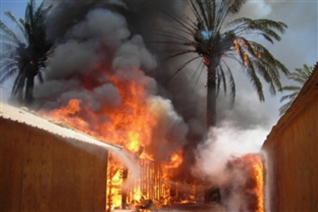Fire destroys a U.S. Marine compound at Entry Control Point-5, a post where Marines and Iraqi police safeguard those entering the city of Fallujah, June 25, 2008. The compound was used by Marines assigned to Company L, 3rd Battalion, 6th Marine Regiment. 

