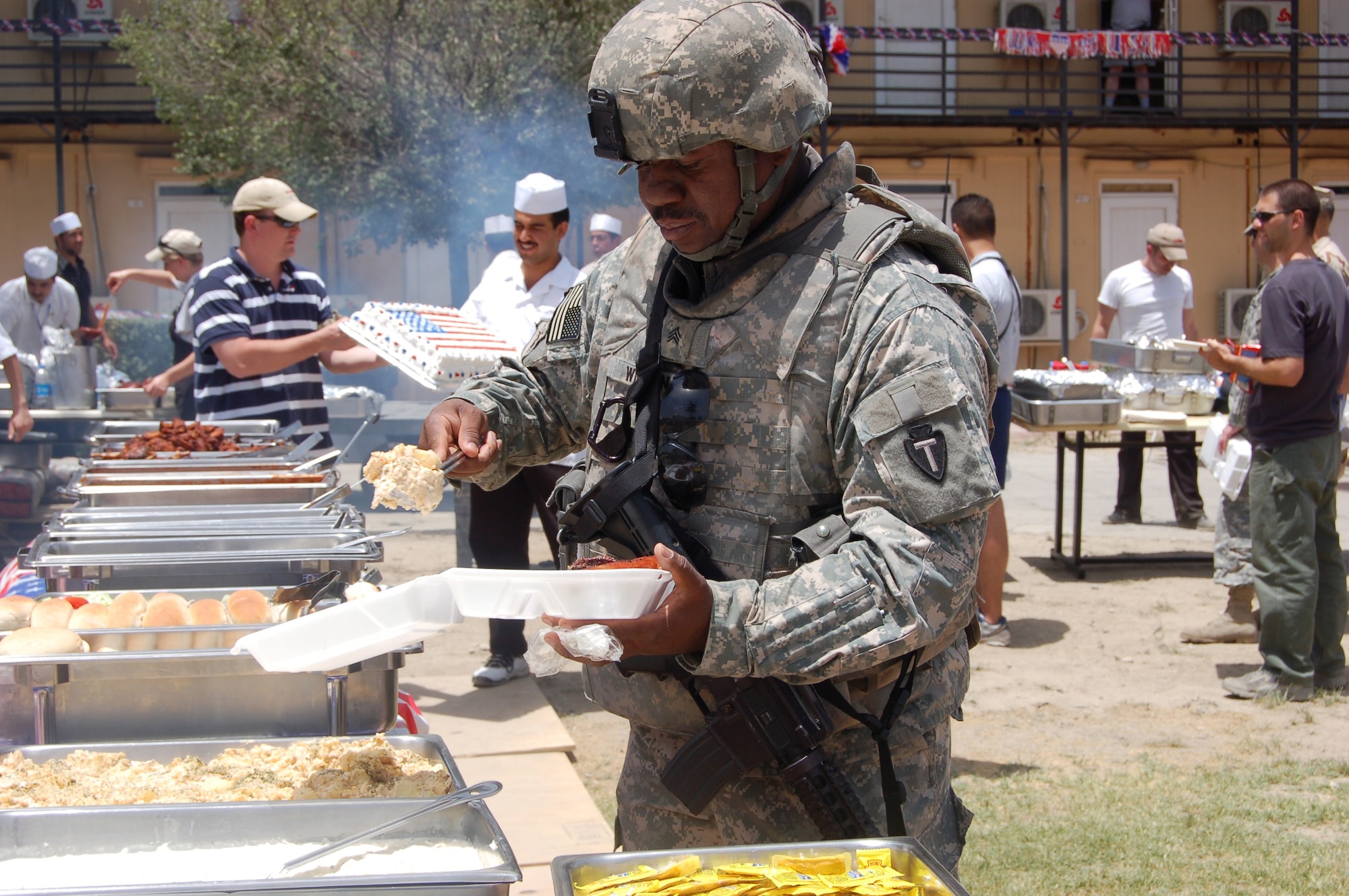 Army Sgt. Robert Wilson, Combined Security Transition
Command-Afghanistan, fills a plate with barbecue at Camp Eggers'
Independence Day celebration in Kabul, Afghanistan. Servicemembers
participated in a myriad of traditional Fourth of July events including
a basketball tournament, horse shoes and a pie-eating contest. (U.S. Air Force photo/Staff Sgt. Beth Del Vecchio)