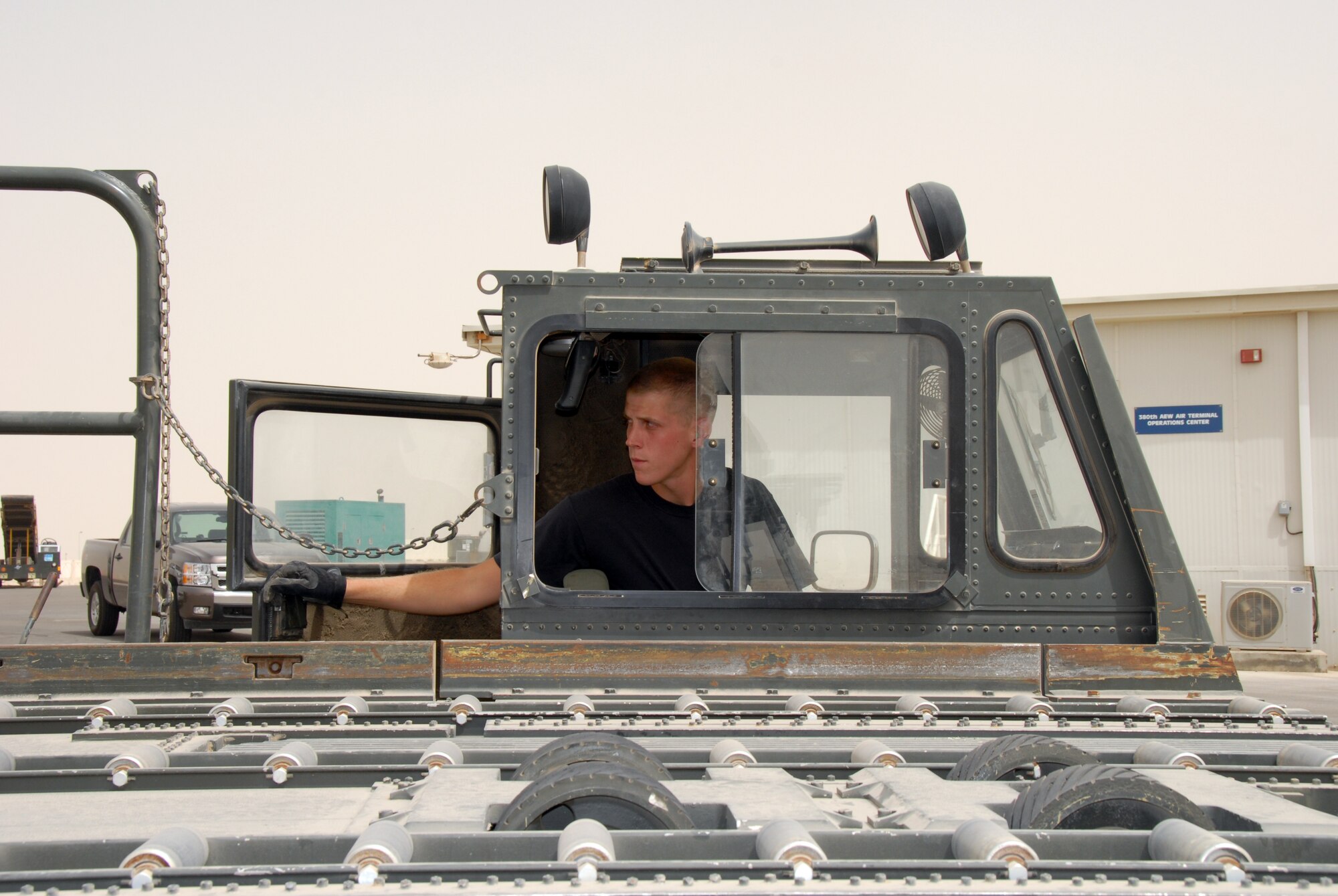 Staff Sgt. Patrick David, 380th Expeditionary Logistics Readiness Squadron Air Terminal Operation Center, looks on inside the cab of a 60K-Loader as a pallet is loaded July 2. (U.S. Air Force photo/Airman 1st Class Kelly LeGuillon)