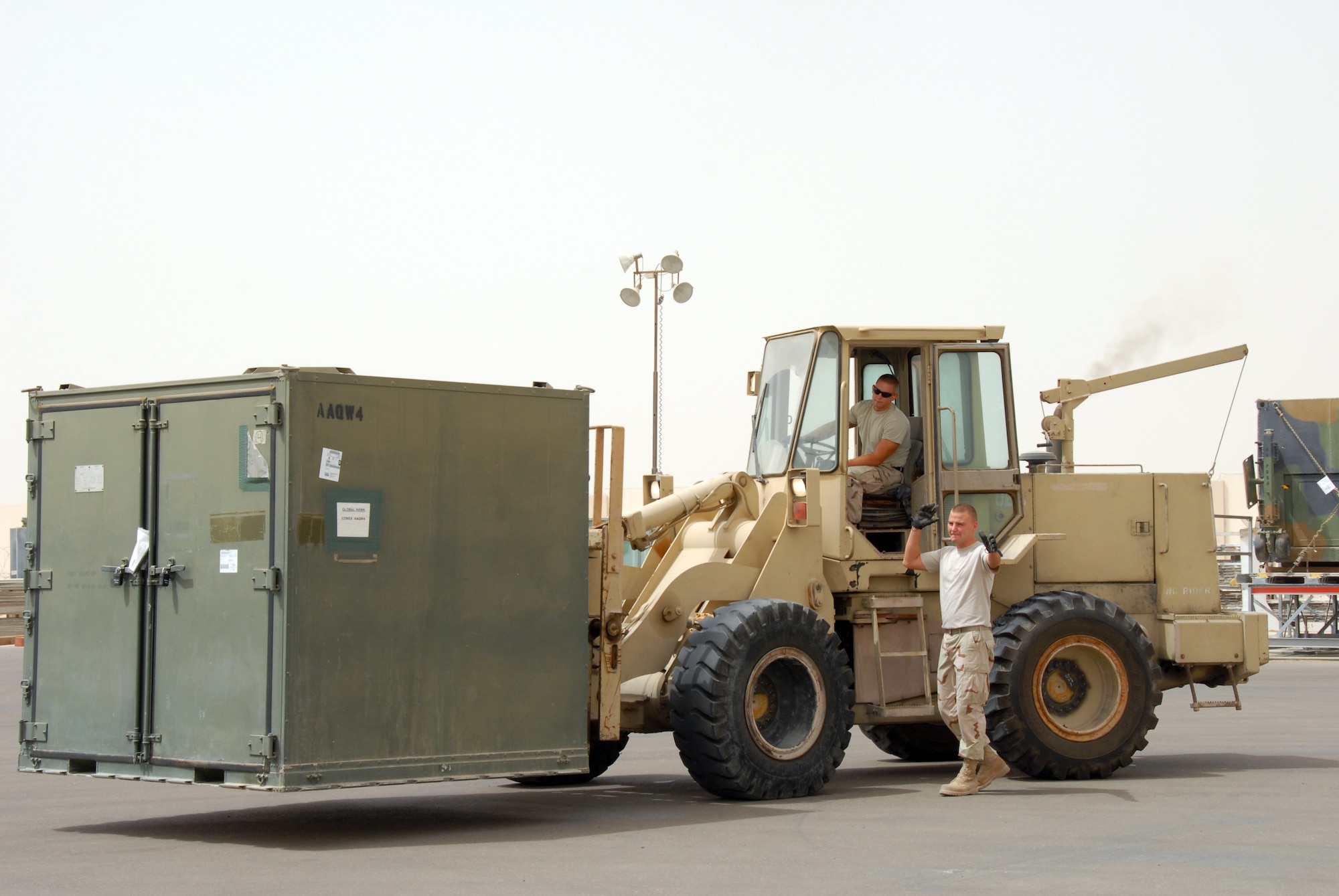 Senior Airman Thomas Elswick (left), and Staff Sgt. Matthew Drangstveit (right), both from the 380th Expeditionary Logistics Readiness Squadron's Air
Terminal Operation Center, load a pallet on a 60K-Loader July, 2. (U.S. Air Force photo/Airman 1st Class Kelly LeGuillon)