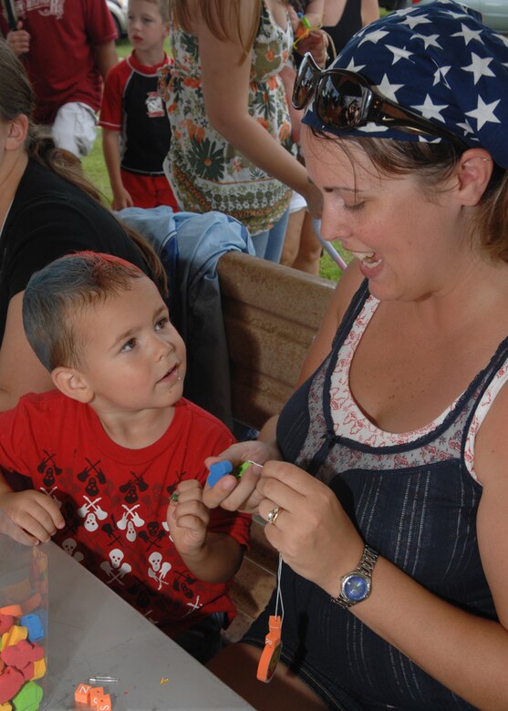 Shalon Royer and son Jaelin Royer make necklaces at one of the many arts and crafts stations during Freedom Fest at Arc Light Park here July 3. Freedom Fest is hosted by the 36th Force Support Squadron and held annually to recognize and celebrate our Independence Day. (U.S. Air Force photo by Airman 1st Class Nichelle Griffiths)