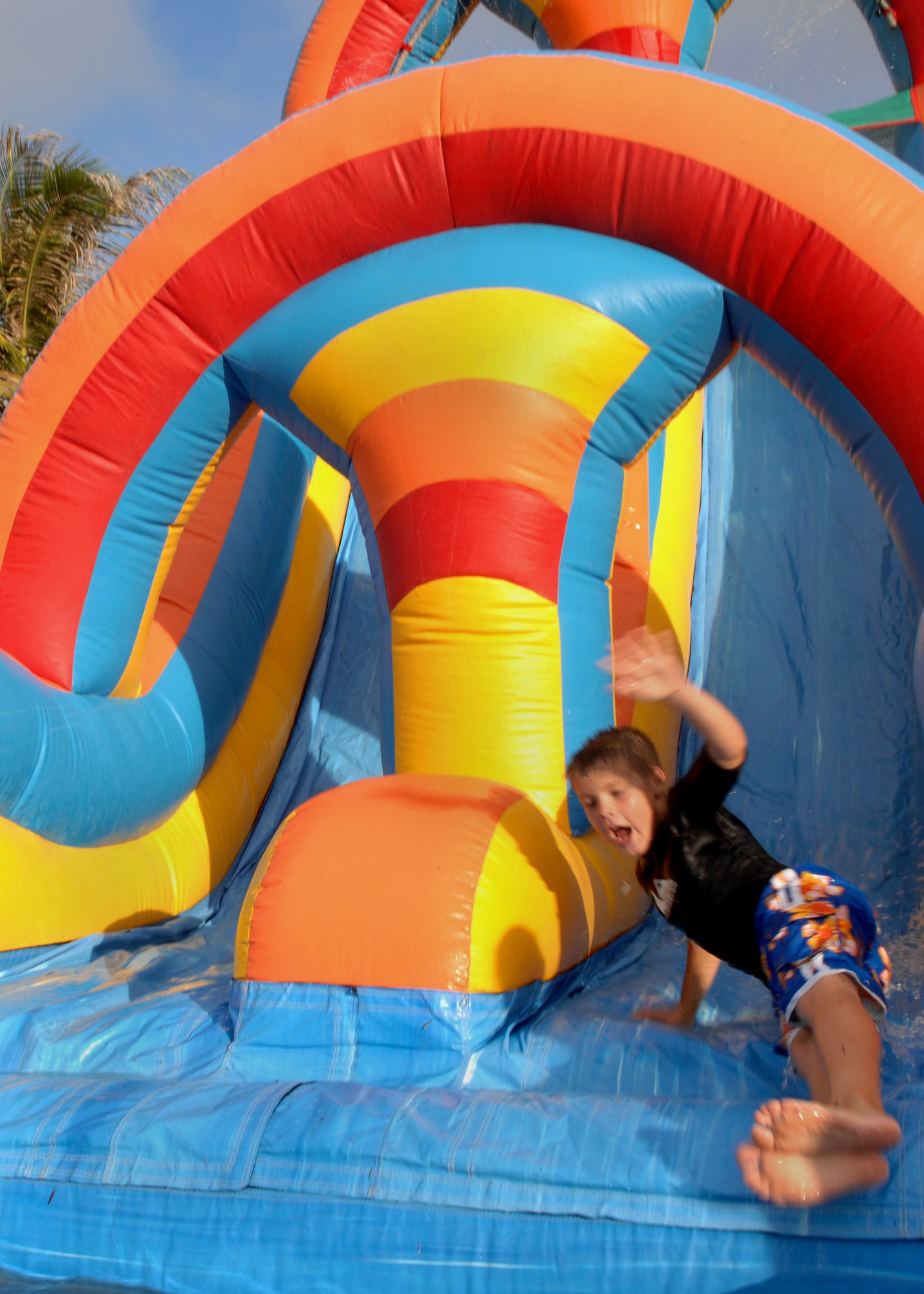 Brenden Paradis slides down the inflatable water slide into a pool or water during Freedom Fest at Arc Light Park here July 3. The water slide was one of many activities for the children to enjoy at Freedom Fest. Freedom Fest is hosted by the 36th Force Support Squadron and held annually to recognize and celebrate our Independence Day. (U.S. Air Force photo by Airman 1st Class Nichelle Griffiths)