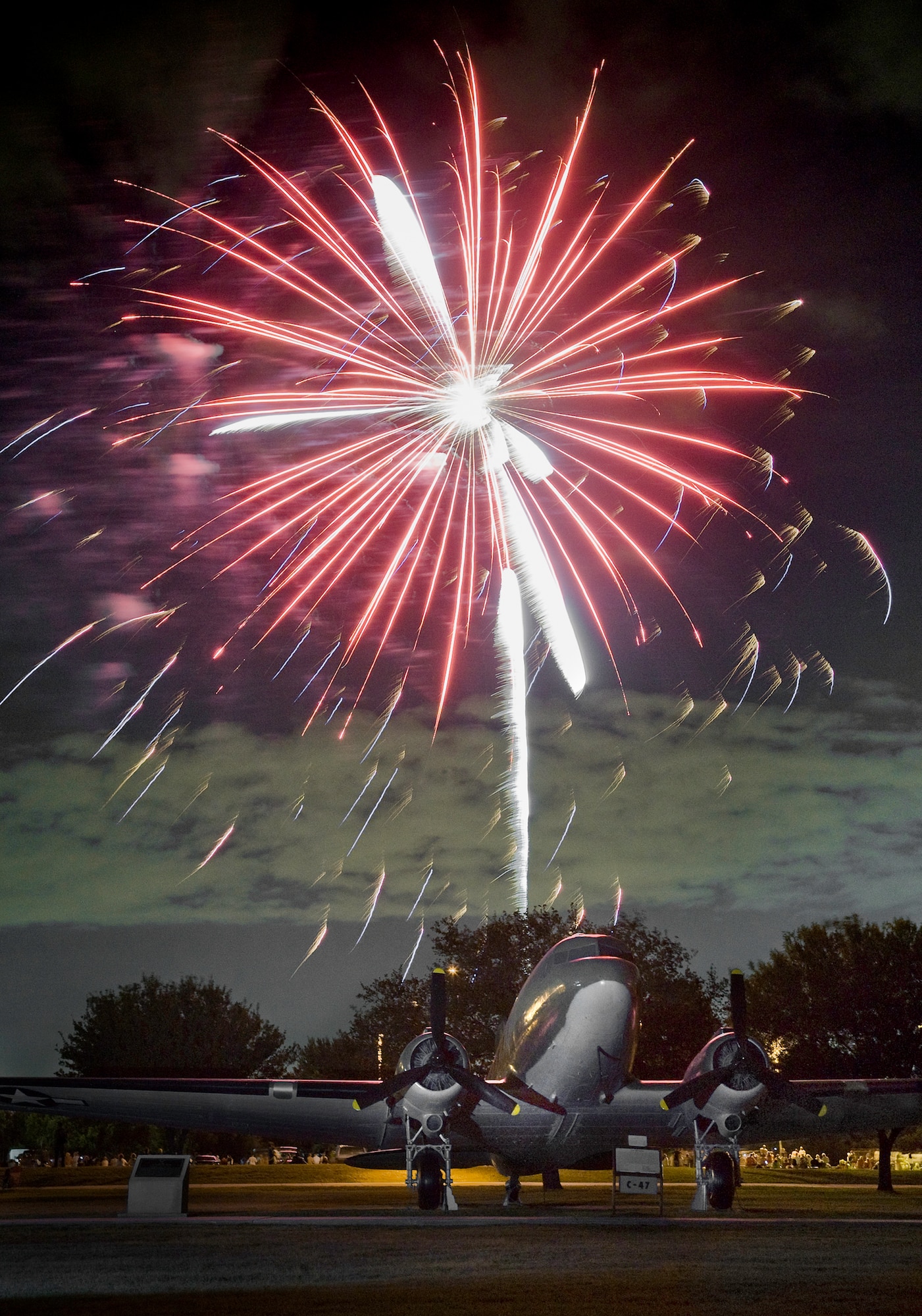A C-47 cargo aircraft highlights the foreground during a f\Fourth of July fireworks display near the parade grounds of the 37th Training Wing at Lackland Air Force Base, Texas. The C-47 was one of the workhorses of the Berlin Airlift humanitarian mission shortly after the birth of of the U.S. Air Force in 1947. (U.S. Air Force photo/Lance Cheung)
