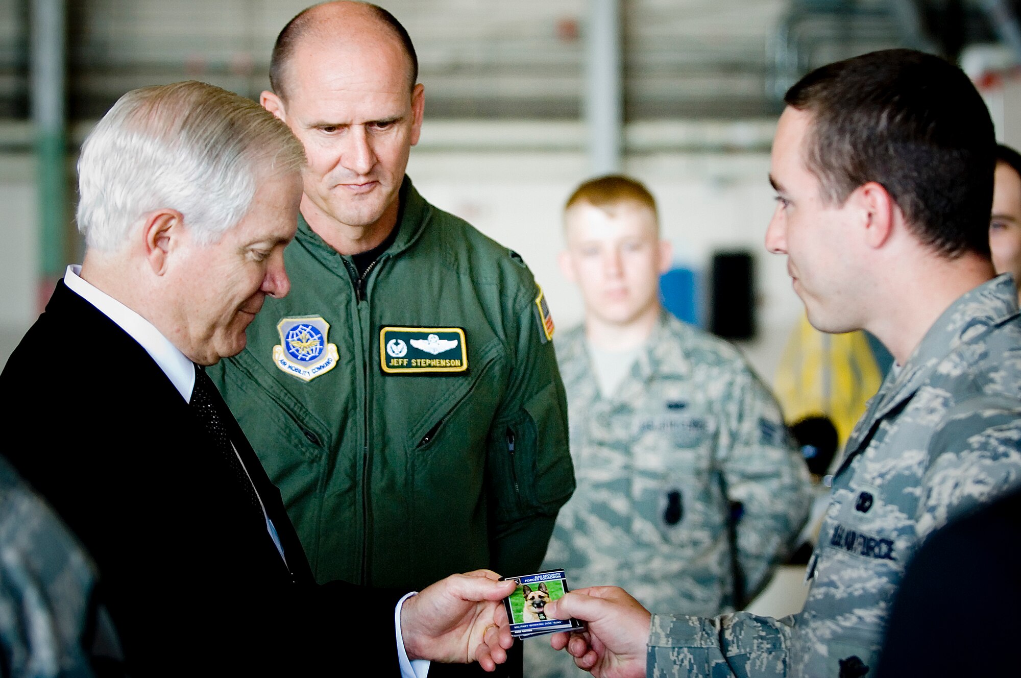 Senior Airman Brian LeCloux, 62nd Security Forces Squadron, presents a military working dog information card to Secretary of Defense Robert M. Gates, during a static display presentation here Monday. (U.S. Air Force photo/Abner Guzman)