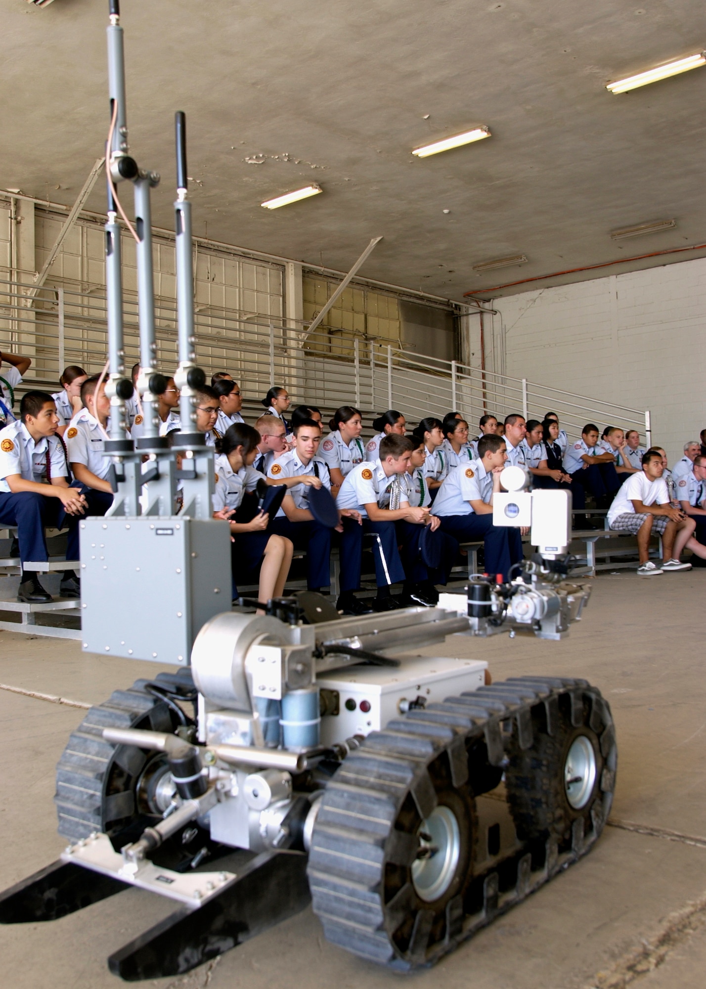 A group of Air Force Junior ROTC cadets look at a demonstration of a bomb detection robot inside a hangar at March Air Reserve Base EOD. The robot, nicknamed “Wally,” is used to detect and disarm explosives remotely.  (U.S. Air Force photo by Senior Airman David K. Flaherty)