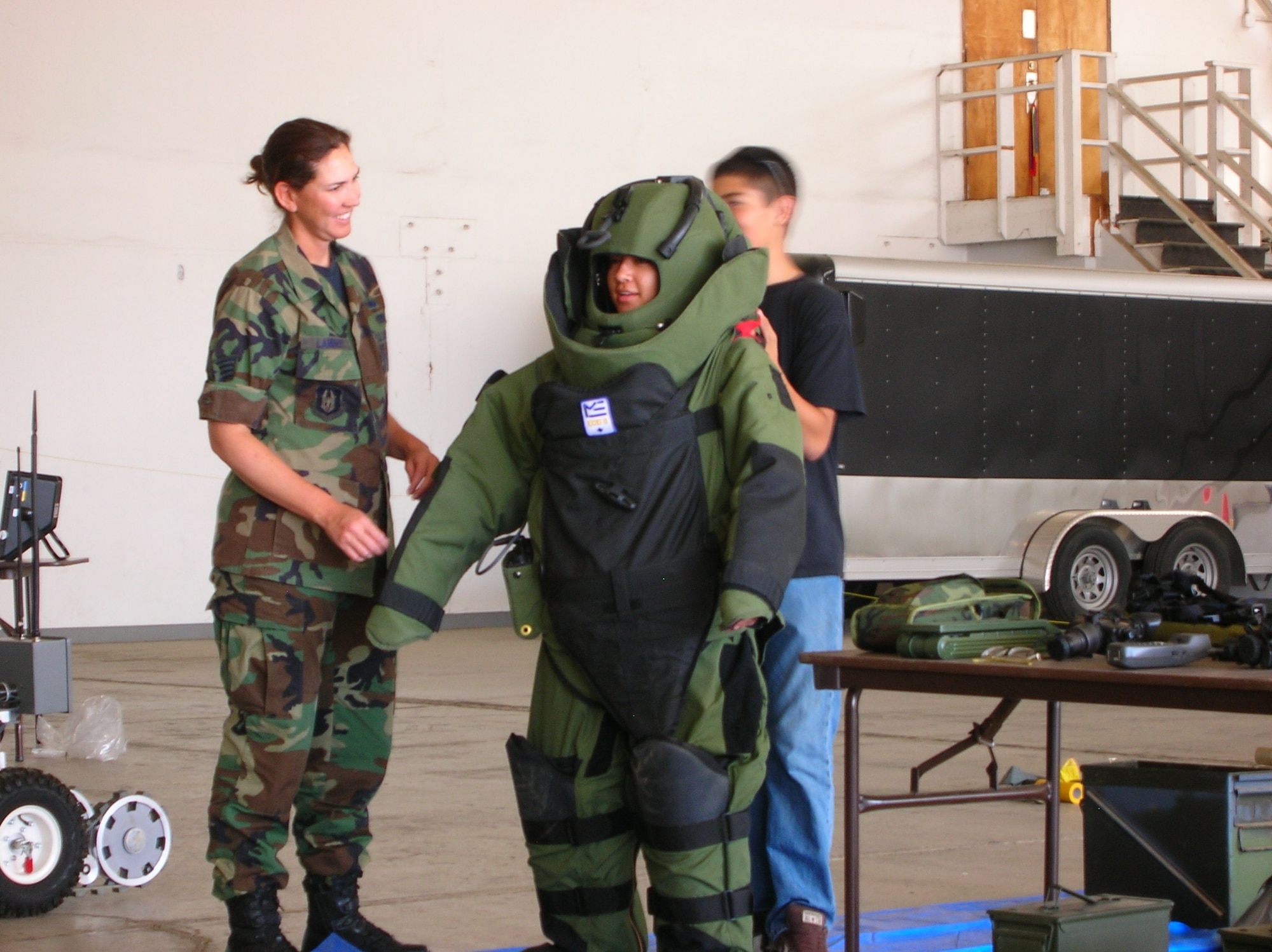 Staff Sgt. Mary Lambert helps an Air Force Junior ROTC cadet get into a bomb suit used by March Air Reserve Base EOD techs to protect against bomb blasts and shrapnel. (U.S. Air Force photo by Daniel Pilkington)
