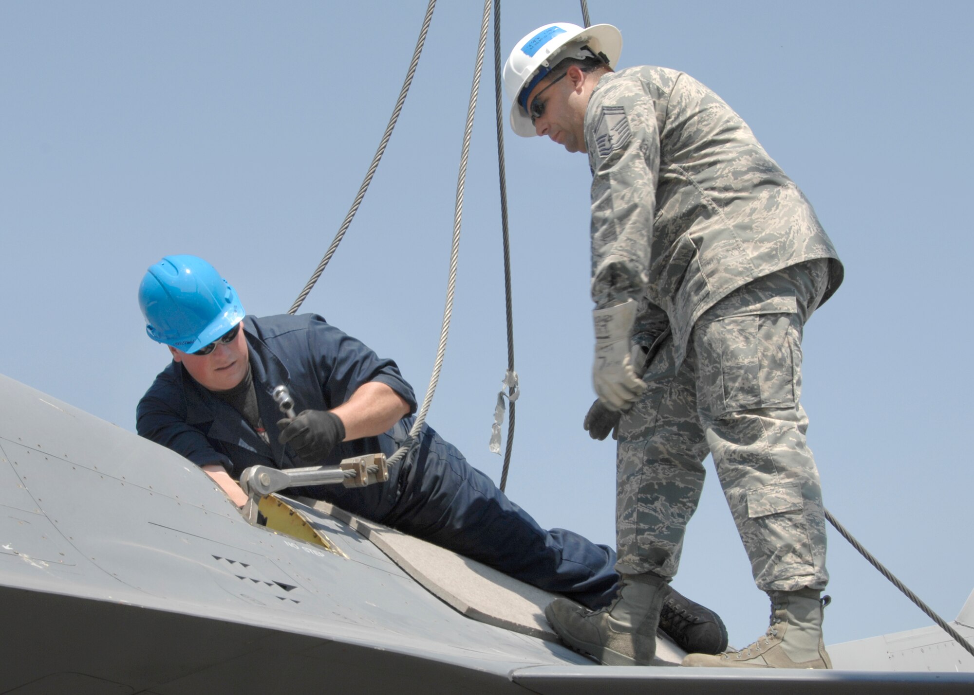 Air Force Reserve Senior Master Sgt. Mike Iarossi, 419th Maintenance Squadron flight chief, watches over Staff Sgt. Steve Zack of the 419th Maintenance Squadron as he attaches the lifting sling to an F-16 aircraft. (U.S. Air Force photo/Sam Shore)