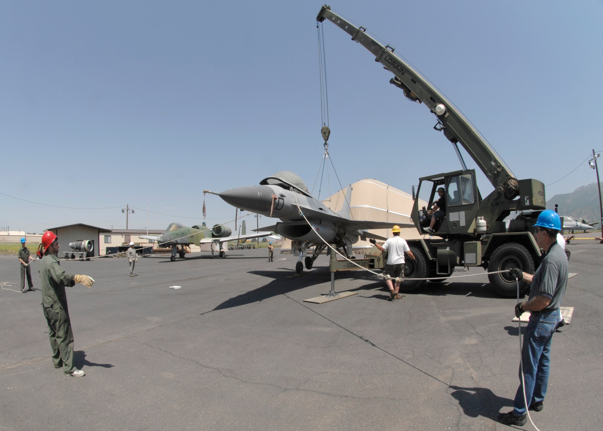 Air Force Reserve Tech. Sgt. Andy Huff, 419th Maintenance Squadron, tells Tech. Sgt. Gary Andersen, 419th Maintenance Squadron, to take up the slack on one of the F-16 aircraft lines as the aircraft is being lifted. (U.S. Air Force photo/Sam Shore)