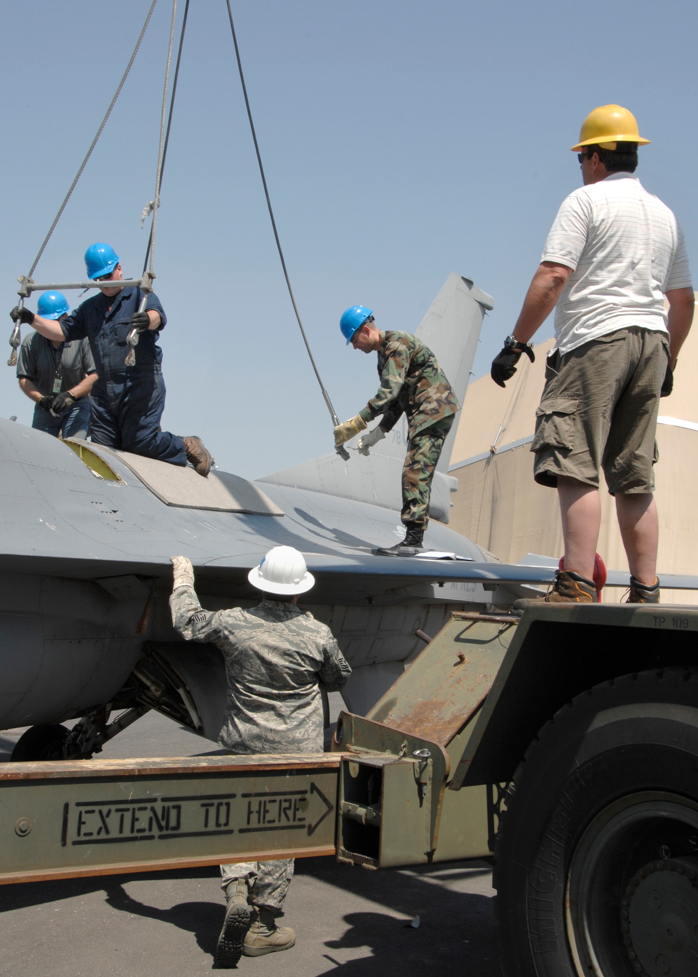Personnel from the 419th Maintenance Squadron and 388th Equipment Maintenance Squadron prepare to attach a lifting sling to an F-16 aircraft at Hill Air Force Base, Utah on 2 July 2008.  Air Force Senior Master Sgt. Mike Iarossi, 419th Maintenance Squadron, Flight Chief (wearing the white hard hat) instructed a two-day F-16 Crash Recovery training course to personnel in both maintenance units.  This was the first time the two units had conducted crash recovery training as a joint team.  The 419th Fighter Wing and the 388th Fighter Wing were the first reserve and active fighter wings to associate and share the same aircraft.  Personnel from the two units also received assistance from the 75th Logistics Readiness Squadron crane crew to make the lift training possible.  (U.S. Air Force photo/Sam Shore)
