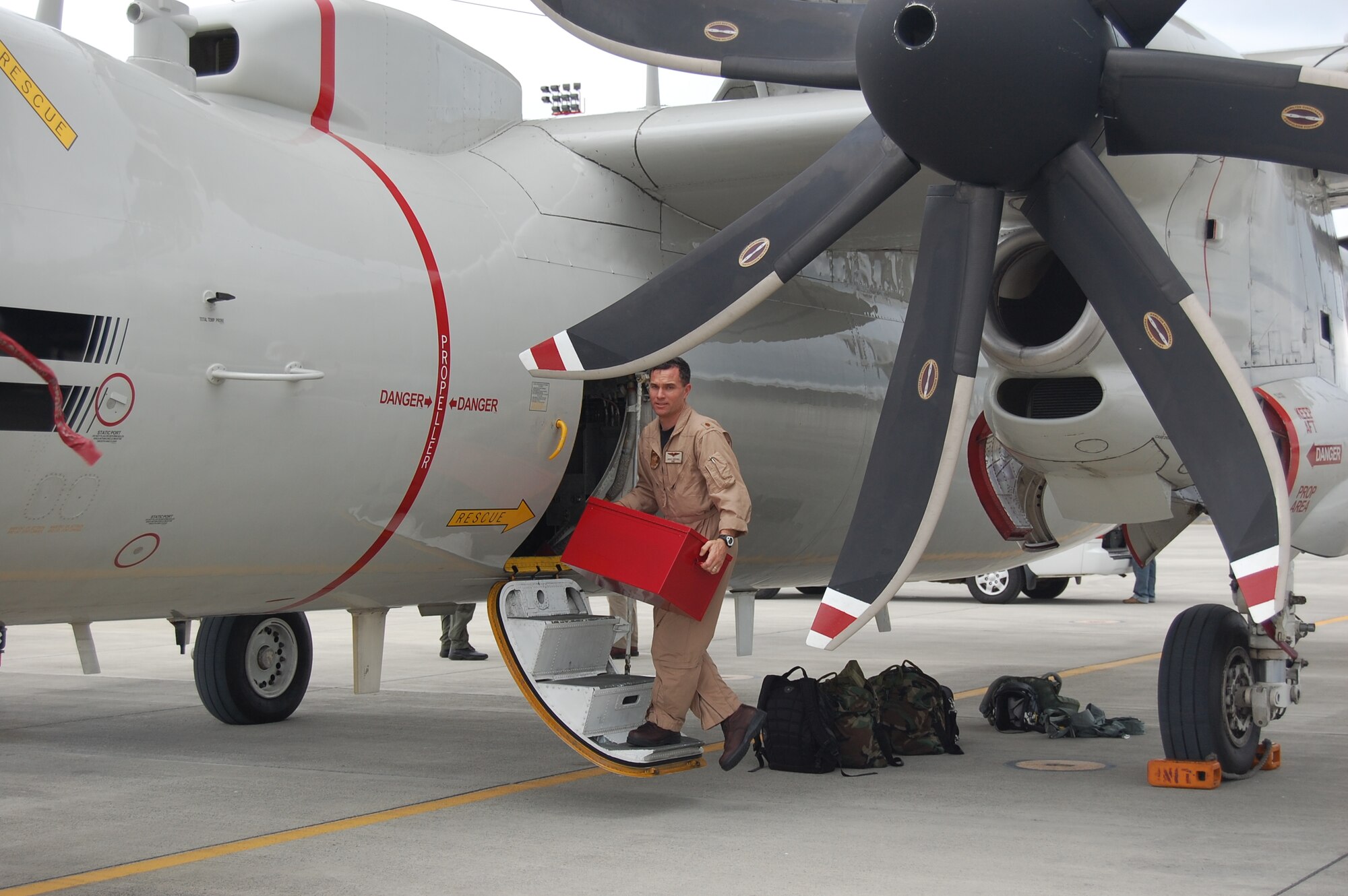 Lieutenant Commander Jerald Rushing, Navy Detachment Operations Officer, offloads equipment from a Navy E-2C Hawkeye on the ramp of Forward Operating Location Manta.  (U.S. Air Force photo/Capt. Ashley Norris)
