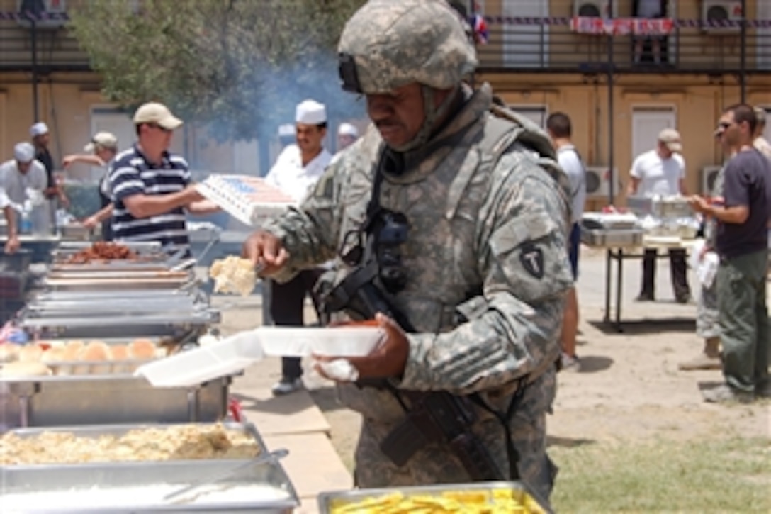 U.S. Army Sgt. Robert Wilson, Combined Security Transition Command-Afghanistan, fills a plate with barbecue at Camp Eggers' Independence Day celebration in Kabul, Afghanistan, July 4, 2008. Servicemembers participated in a myriad of traditional Fourth of July events including a basketball tournament, horseshoes and a pie-eating contest.