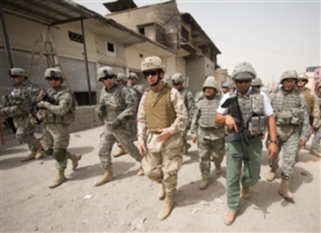 U.S. Navy Adm. Mike Mullen, chairman of the Joint Chiefs of Staff, takes a walking tour of the Sadr City district of Baghdad, Iraq, July 7, 2008. Mullen is on a six-day tour of the region to visit troops and host a USO contingent including NFL All-Pros Drew Brees, quarterback of the New Orleans Saints, and Osi Umenyiora, defensive end for the New York Giants, as well as the Dallas Cowboy cheerleaders and former Marshall University football coach Jack Lengyel. 