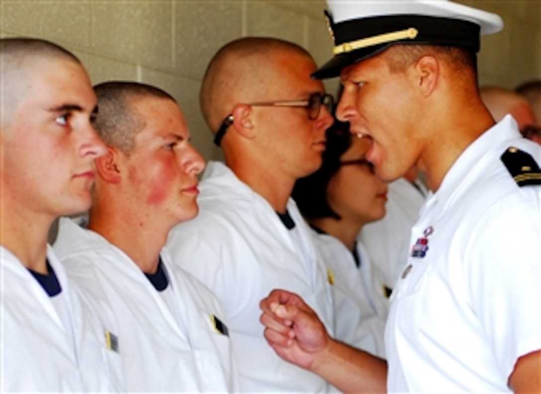 A U.S. Naval Academy upper-class midshipman instructs a Plebe from the class of 2012 on military bearing during induction day at the academy in Annapolis, Md., on July 2, 2008.  Induction day is the beginning of Plebe summer, the six-week process of turning civilians into midshipmen.  