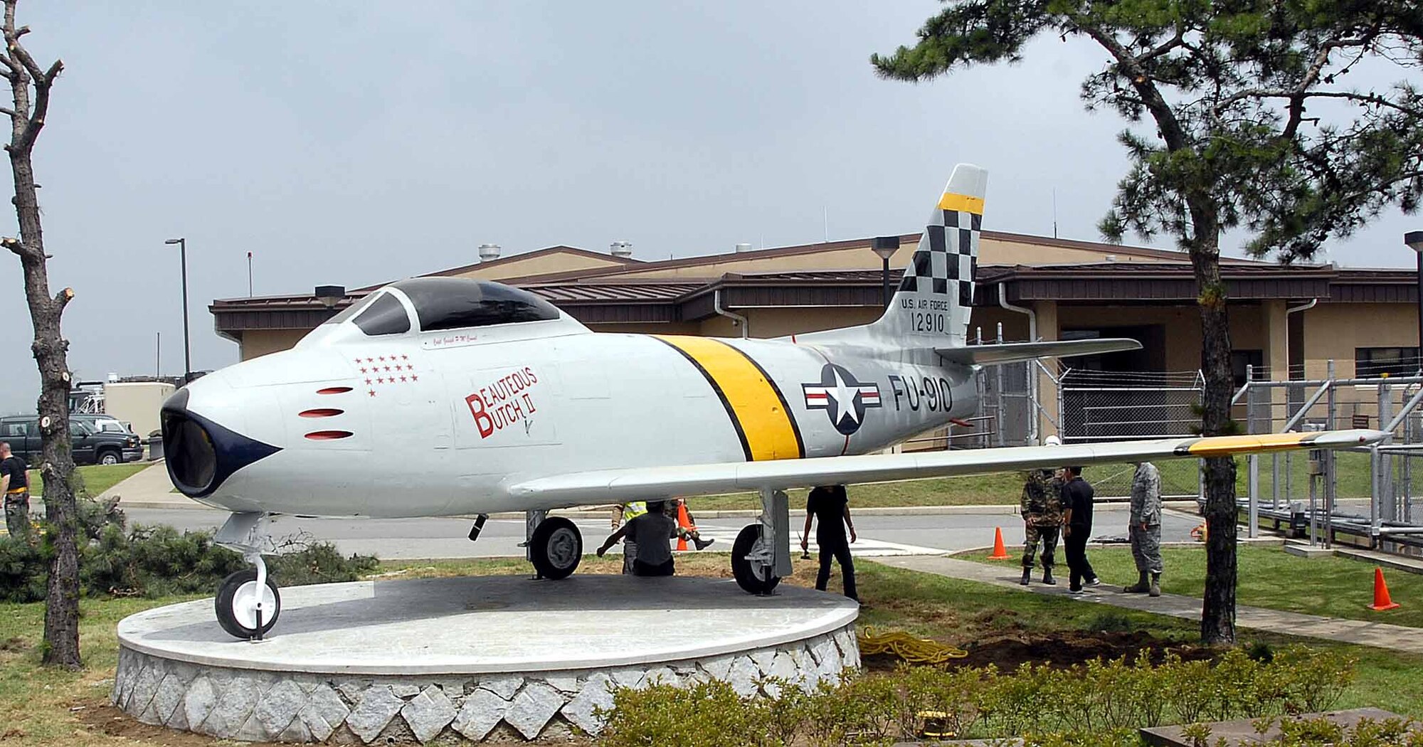 OSAN AIR BASE, Republic of Korea -- A F-86 Sabre static display now rest in front of base operations. Members of the 51st Maintenance Squadron moved the aircraft to its final resting place July 3. The movement was the final portion of a restoration project by members of the 51st MXS which included removing years of weathered paint, coatings, distinctive markings, and repainting hand crafted stencils to match the original 1951 aircraft identification and checkertail design. (U.S. Air Force photo/Staff Sgt. Scottie McCord)
