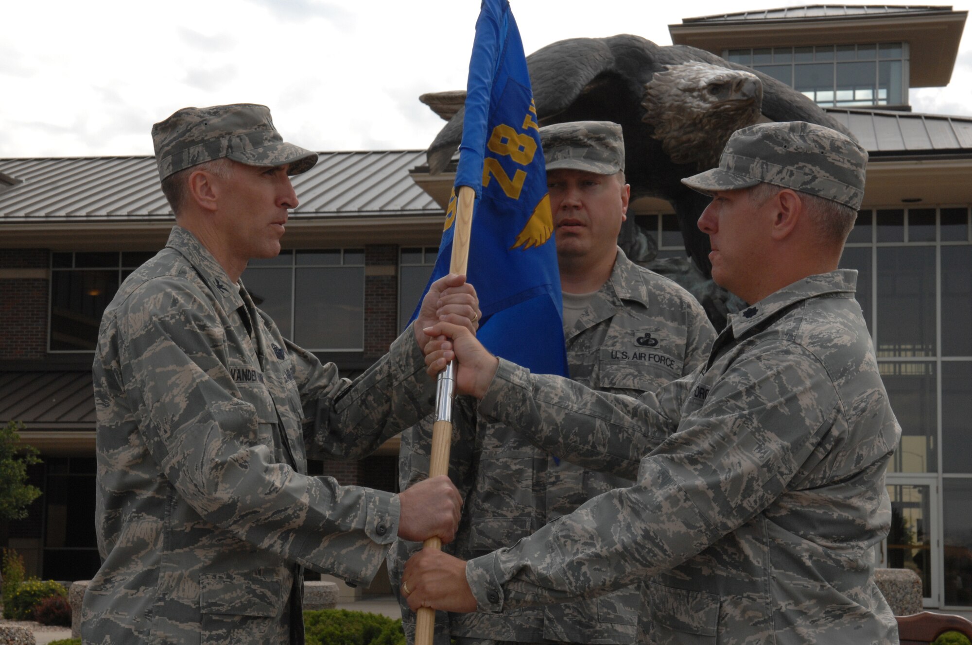 (Right) Lt. Col. Michael P. Dahlstrom, 28th Comptroller Squadron commander, relinquishes command by passing the guidon to Col. Scott Vander Hamm, 28th Bomb Wing commander, during a change of command ceremony, here July 8. Colonel Dahlstrom will take command of the 375th Comptroller Squadron at Scott Air Force Base, Ill. (U.S. Air Force photo/Airman 1st Class Adam Grant)
