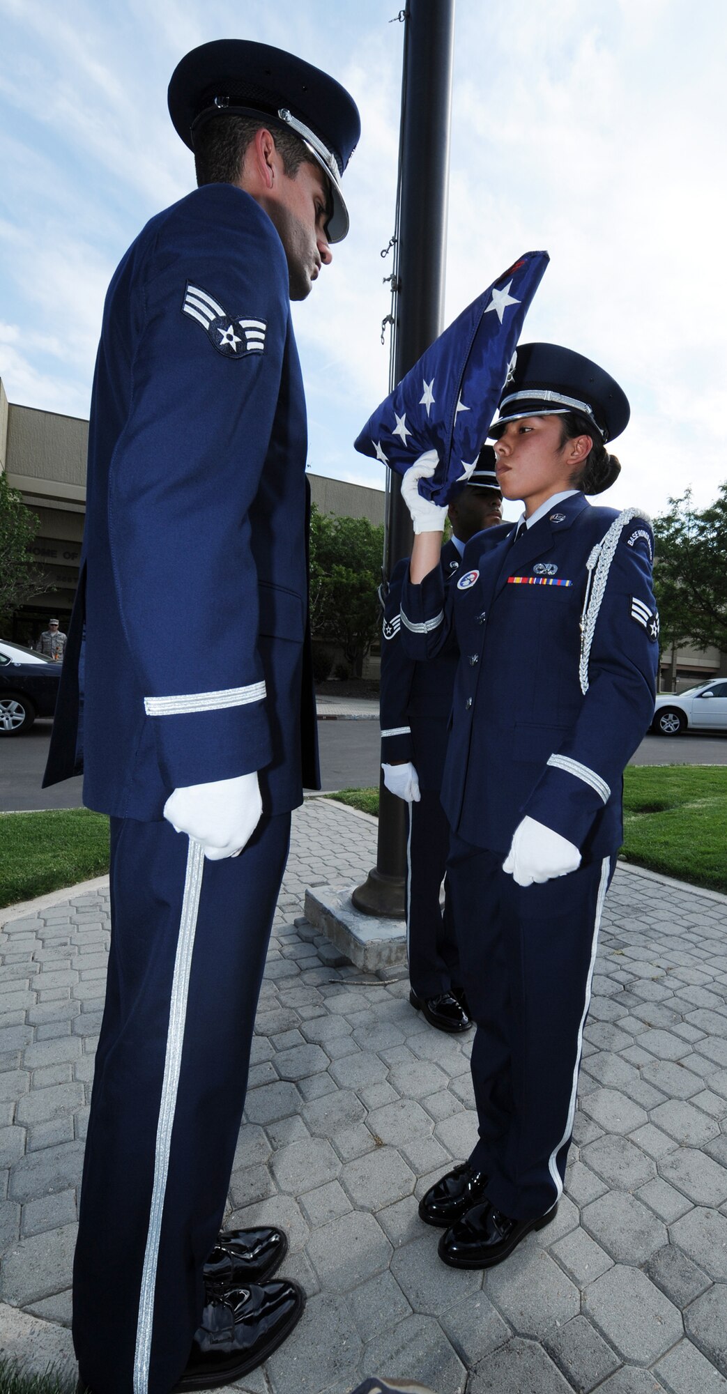 MOUNTAIN HOME AIR FORCE BASE, Idaho - Senior Airman Cindy DeLeonn (right), 366th Component Maintenance Squadron honor guard member, and Senior Airman Mark Ellis, 366th Communications Squadron honor guard member, present the American flag after folding it at the 366th Fighter Wing formal retreat July 1. The base honor guard performs many functions around the base to support the wing. (U.S. Air Force photo/ Airman 1st Class Stephany Miller)