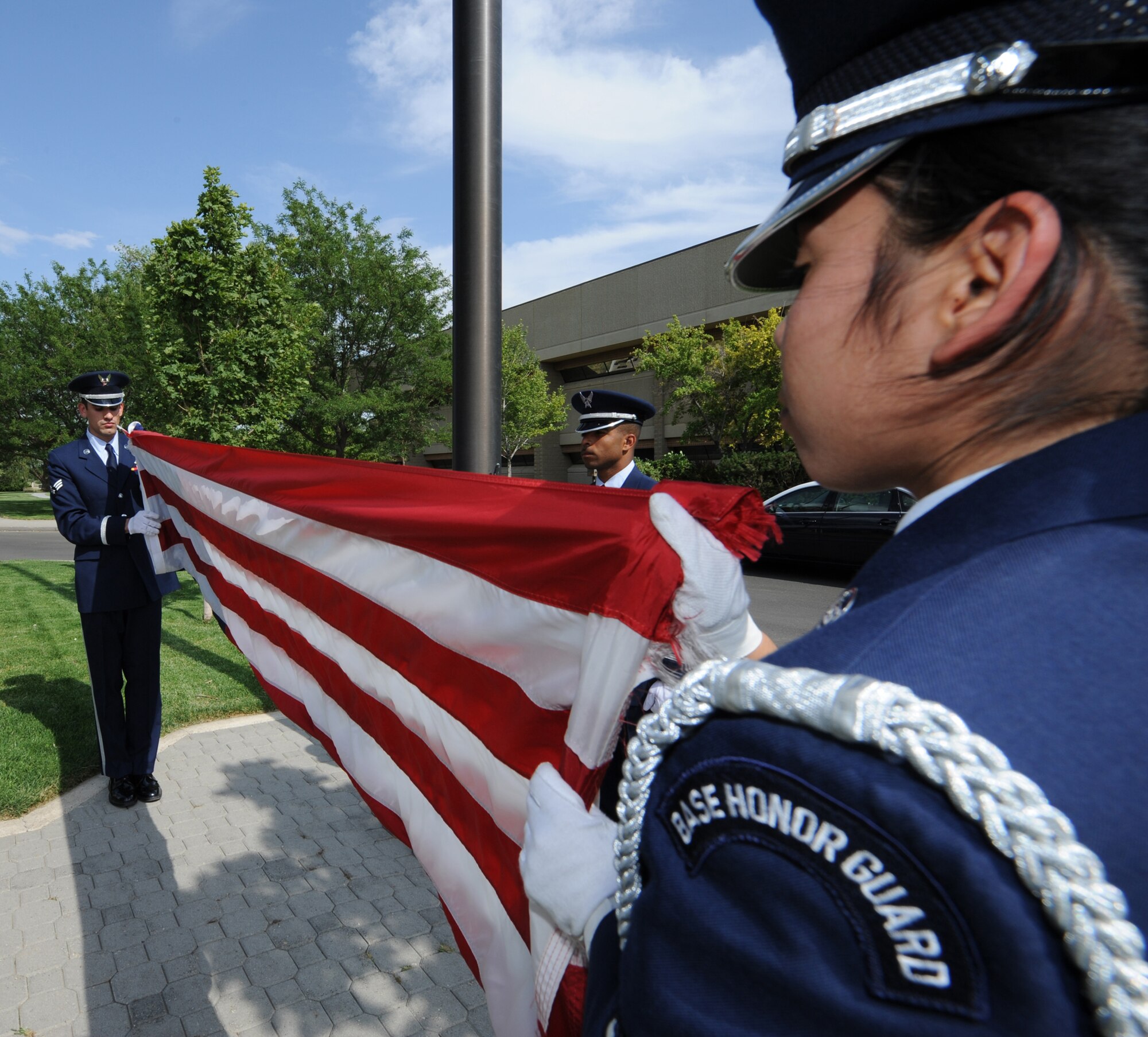 MOUNTAIN HOME AIR FORCE BASE, Idaho - Staff Sgt. Emmanuel Santillan, 366th Services Squadron honor guard member, helps fold the American flag with fellow honor guard members Senior Airman Cindy DeLeon (left), 366th Component Maintenance Squadron honor guard member, and Senior Airman Mark Ellis (right), 366th Communications Squadron honor guard member, at the 366th Fighter Wing formal retreat July 1. The base holds formal retreats once a month from March through October with different groups responsible for conducting the formation each month. (U.S. Air Force photo/ Airman 1st Class Stephany Miller)