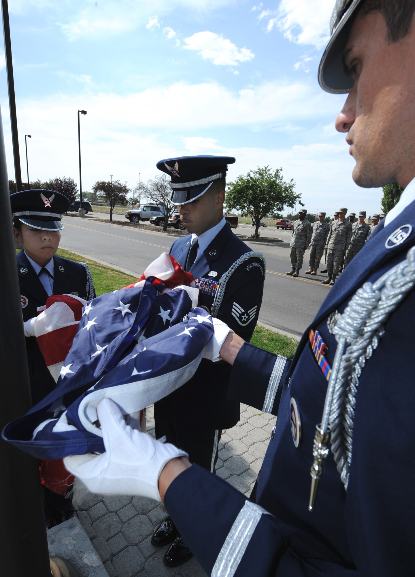 MOUNTAIN HOME AIR FORCE BASE, Idaho - Staff Sgt. Emmanuel Santillan, 366th Services Squadron honor guard member, helps fold the American flag with fellow honor guard members Senior Airman Cindy DeLeon (left), 366th Component Maintenance Squadron honor guard member, and Senior Airman Mark Ellis (right), 366th Communications Squadron honor guard member, at the 366th Fighter Wing formal retreat July 1. The base honor guard performs many functions around the base to support the wing. (U.S. Air Force photo/ Airman 1st Class Stephany Miller)