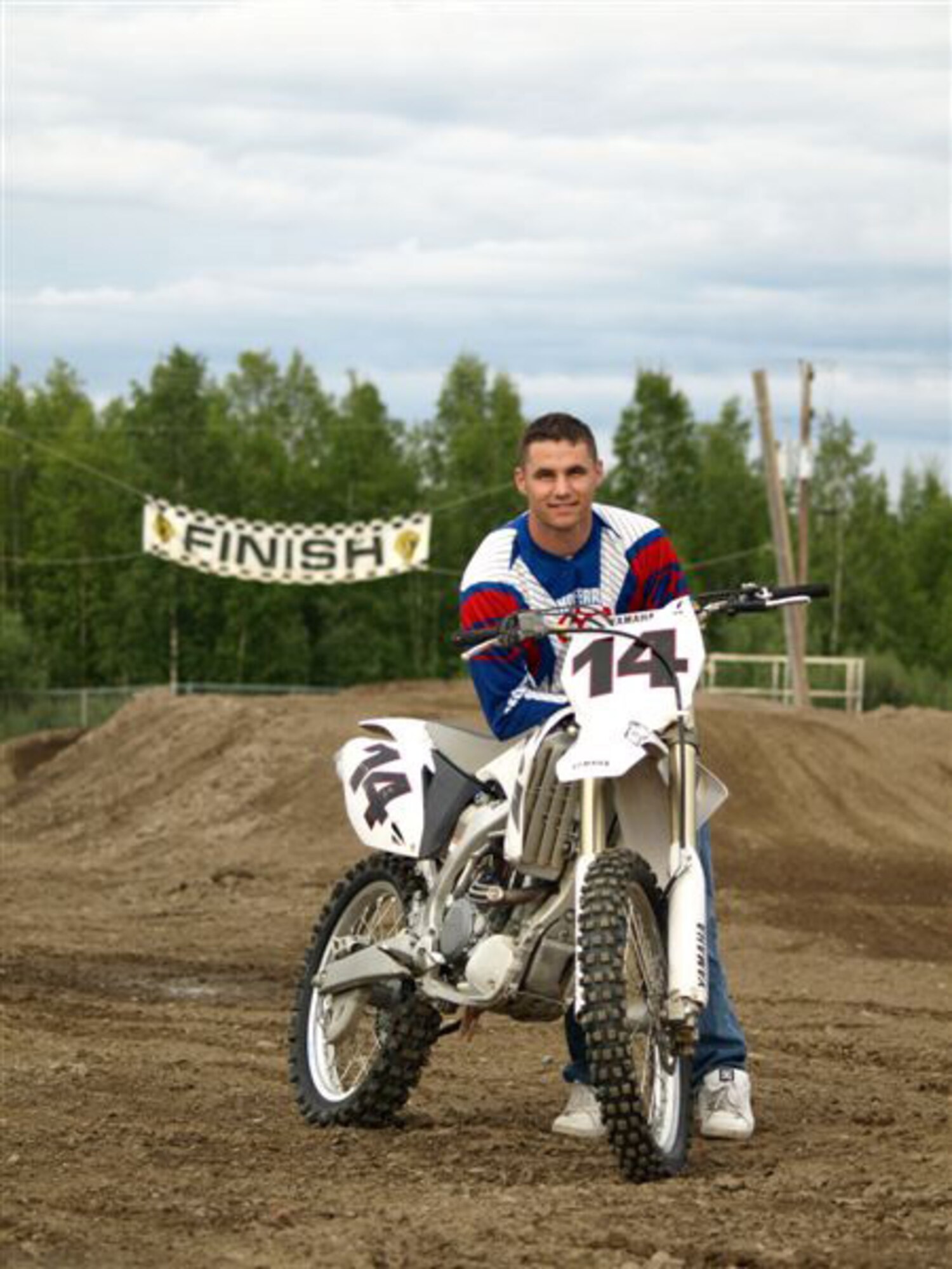 Senior Airman Shawn Martin, 354th Maintenance Squadron aircraft structural maintainer, poses with his dirt bike, a Yamaha YZ250F. He races with the Fairbanks Motorcycle Racing Lions competitively and recreationally. (U.S. Air Force photo by Lara Poirrier)