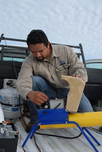 Mike Pacheco, U.S. Department of Agriculture wildlife biologist assigned to the 12th Flying Training Wing safety office, prepares a mobile propane cannon to startle doves in an effort to help relocate them to a less dangerous location. (U.S. Air Force photo by Rich McFadden)