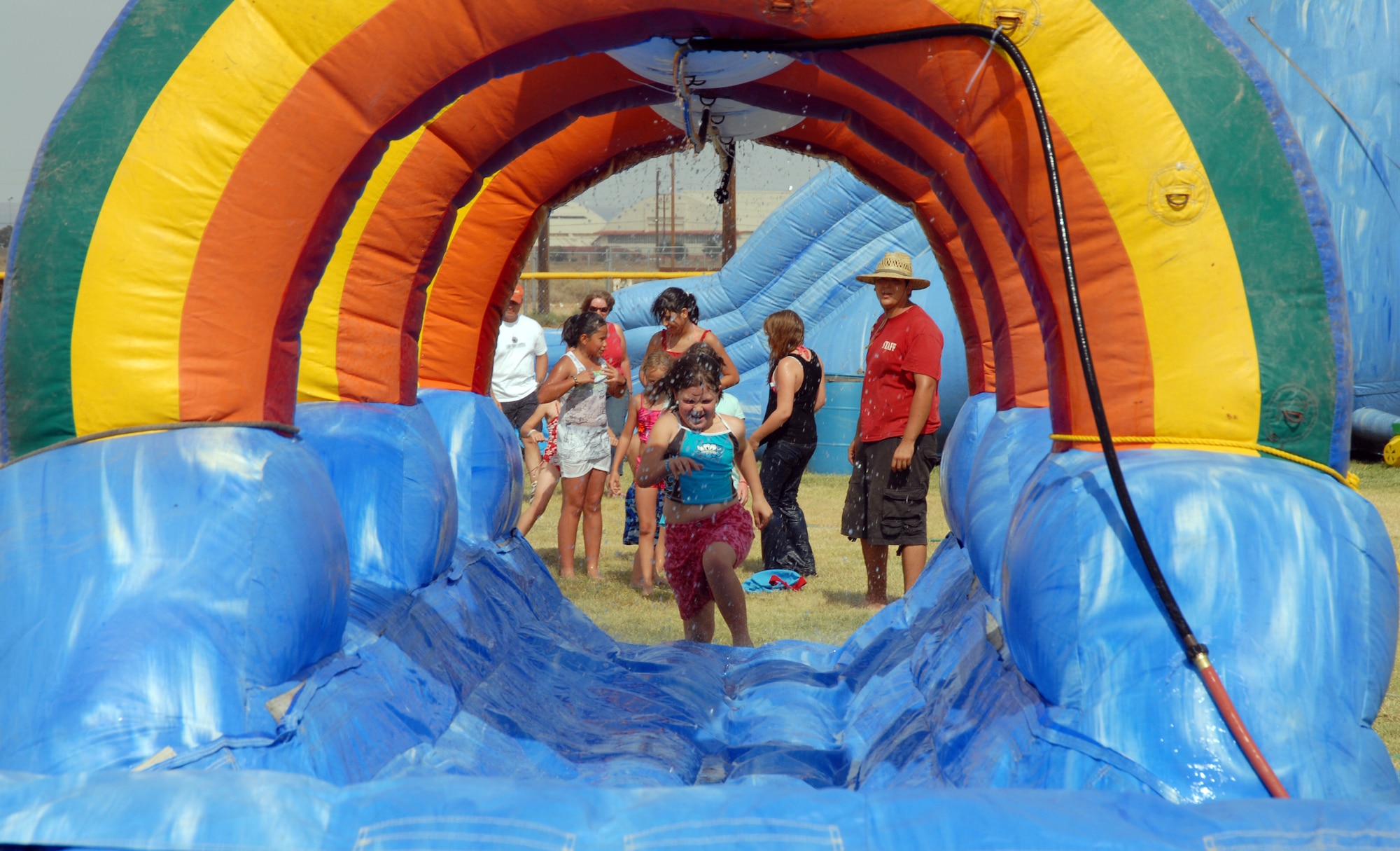 Children run through a slip and slide during the Summer Bash at Robert and Wings Field here July 4. Summer Bash is in celebration of the United States' 232nd birthday. (Air Force photo by Airman 1st Class William O’Brien)