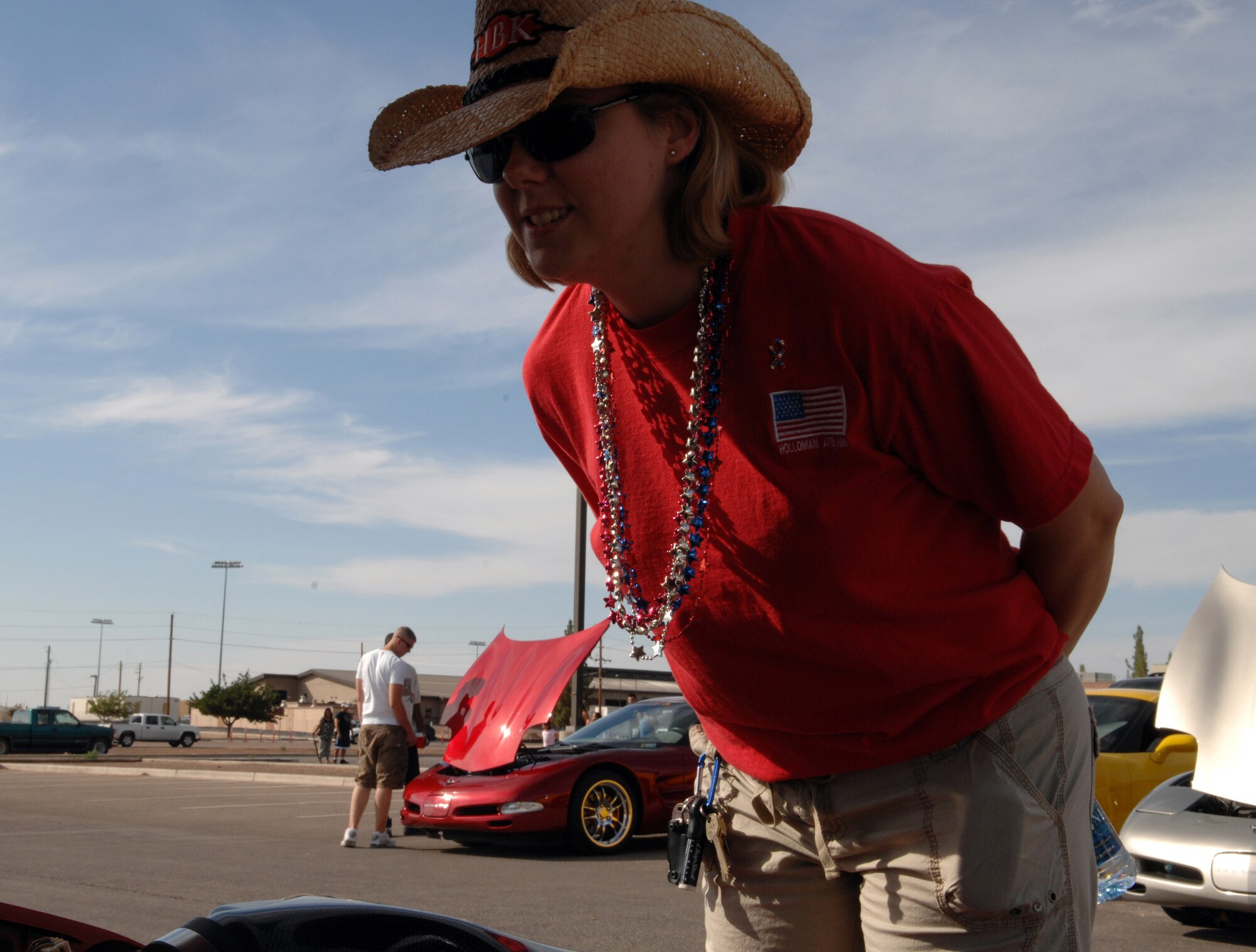 Tech. Sgt. Jean Magee, 49th Force Support Squadron, leans in to check out the engine in a car at the Old Fashioned Independance Day celebration car show at Holloman Air Force Base, N.M., July 3. The car show featured many unique vehicles, from classic cars to modern-day styles.