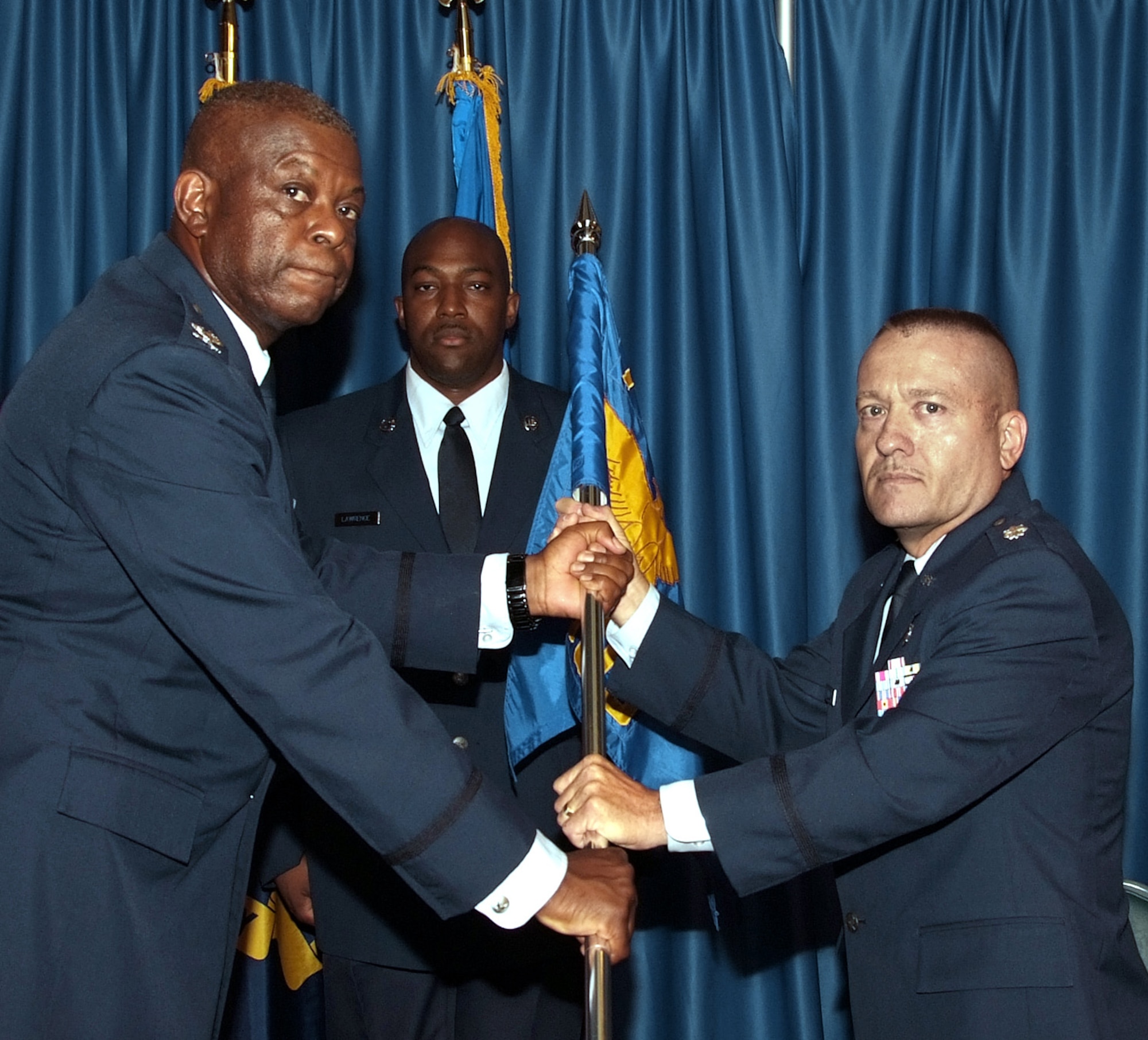 Col. Otha L. Solomon Jr., left, commander of the 71st Medical Group at Vance AFB, Okla., passes command of the 71st Medical Operations Squadron to Lt. Col. Royce M. Terry during a ceremony July 3 at the Vance Collocated Club. In the background is the 71st MDG superintendent, Master Sgt. Mitchell Lawrence. (U.S. Air Force photo by Terry Wasson)