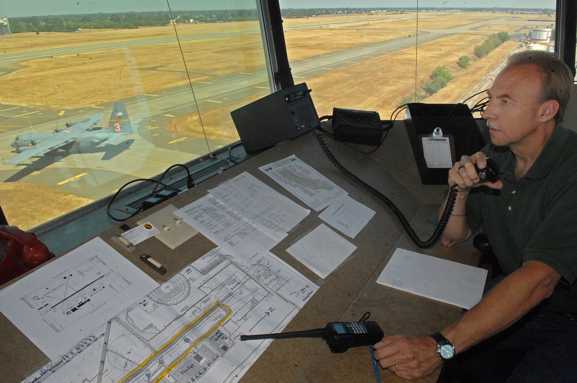 William Grava looks out the window as a C-130 Hercules taxies to the runway to begin firefighting operations July 5 from the McClellan Airfield in California. Mr. Grava is an air traffic control specialist from the Federal Aviation Administration's Northern California Terminal Radar Control. (U.S. Air Force photo/Staff Sgt. Hector Garcia)