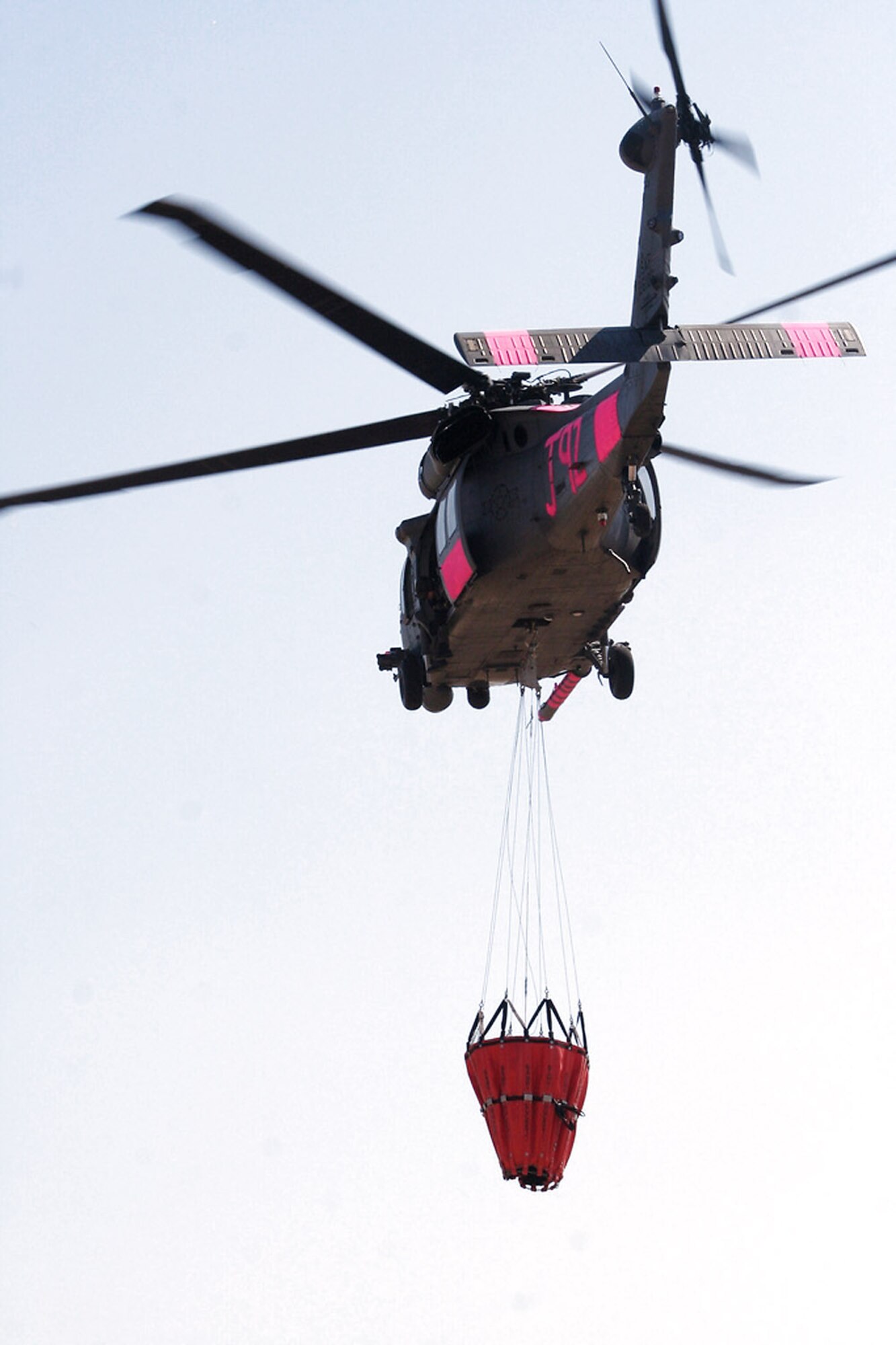 An HH-60G Pave Hawk flies with a water bucket attached July 2 near Sacramento, Calif. The aircrews trained with water buckets to become certified for firefighting suppression duty. The HH-60G is from the 129th Rescue Wing of the California Air National Guard. (U.S. Air Force photo/Master Sgt. Barbara Apkarian) 
