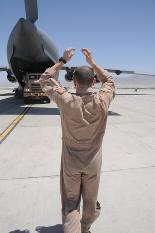 Staff Sgt. Jeffrey Harmon spots a tractor-trailer out of a C-17 at Bagram AB, Afghanistan, June 19.The 14th Airlift Squadron is currently deployed as the 816th Expeditionary Airlift Squadron. Sergeant Harmon is a loadmaster with the 816 EAS. (U.S. Air Force photo/ Senior Airman Tong Duong)
