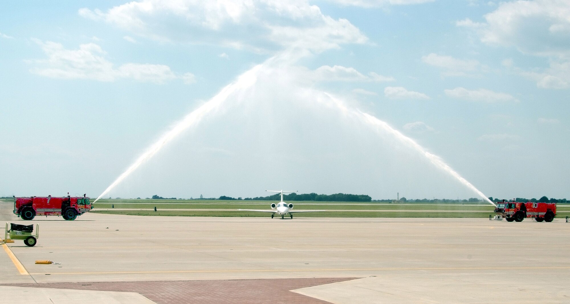 A T-1A Jayhawk, piloted by Col. Richard A. Klumpp Jr., commander of the 71st Flying Training Wing at Vance AFB, Okla., taxis under the crossed sprays of base fire trucks June 30. Colonel Klumpp was taking his fini flight before becoming chief of staff for the Joint Functional Component Command for Integrated Missile Defense at Schriever AFB, Colo. (U.S. Air Force photo by Terry Wasson)